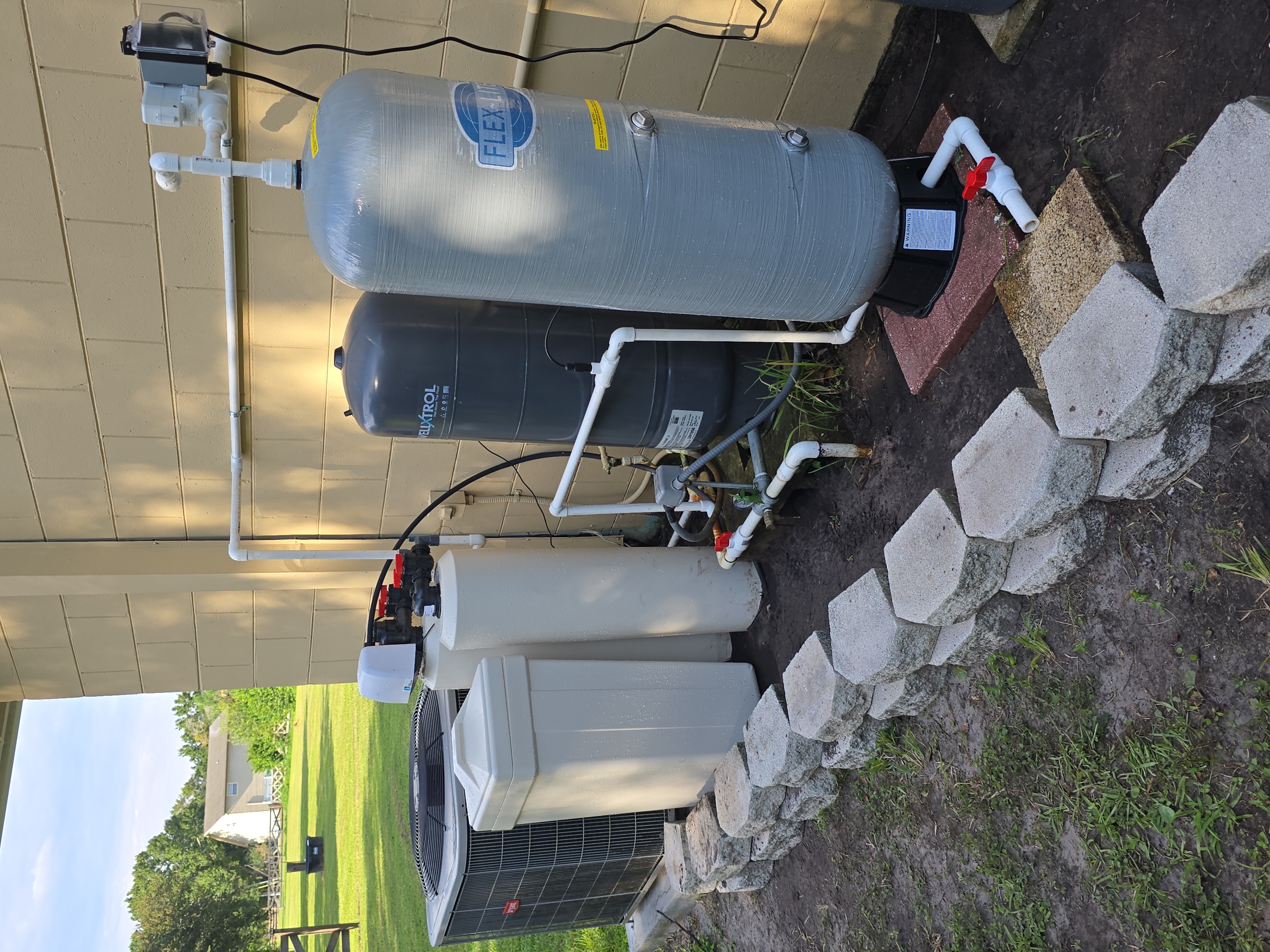 T&K Water Conditioning dual black tank water treatment system with round salt tank in garage