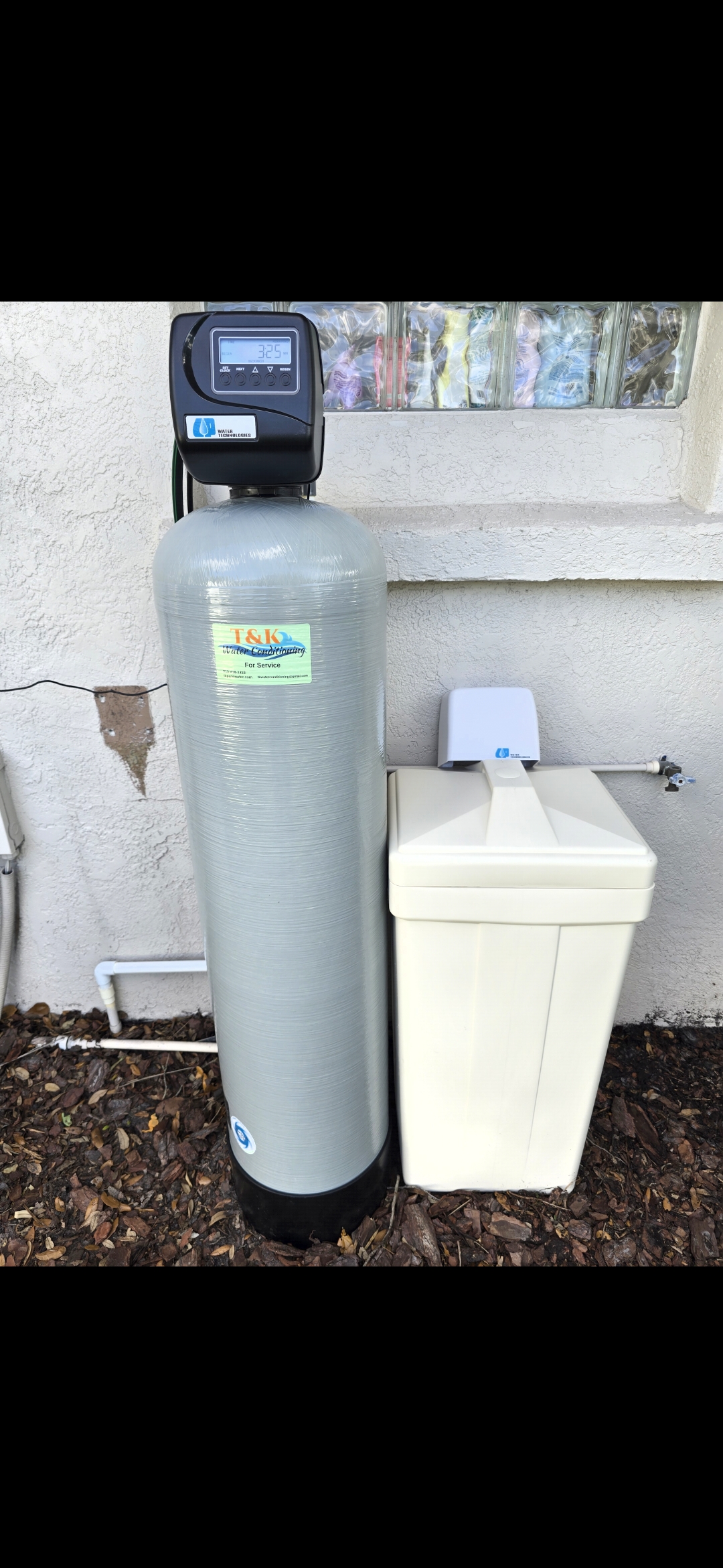 T&K Water Conditioning water softener installed outside Florida home next to salt tank