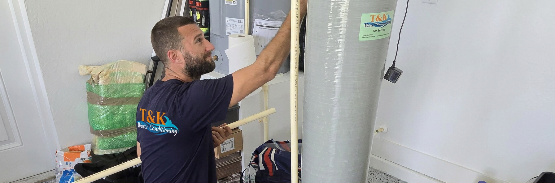 T&K Water Conditioning technician installing a water softener system in a Tampa Bay home