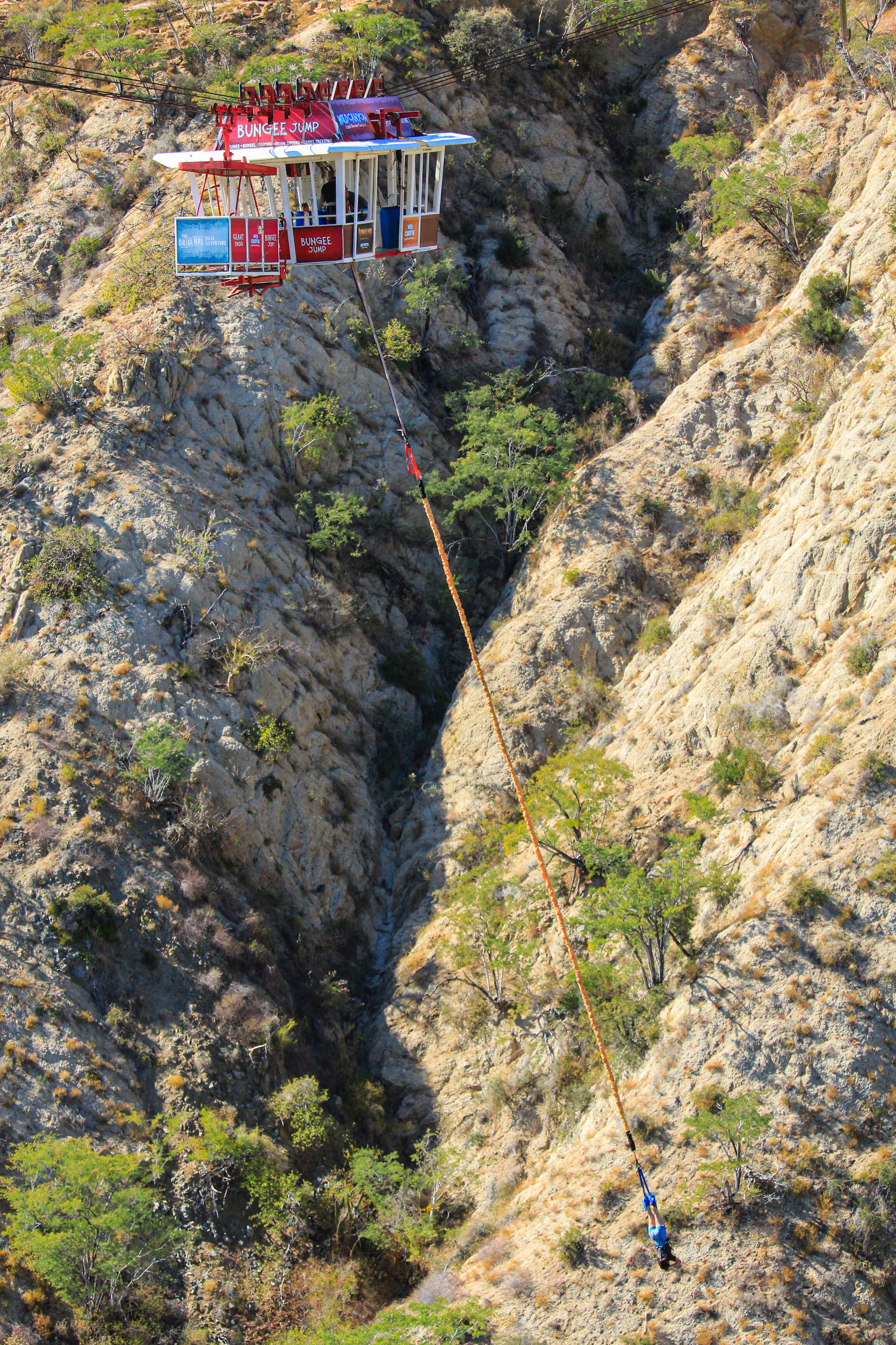 Aerial view of Wild Canyon bungee jump gondola suspended over dramatic Baja canyon