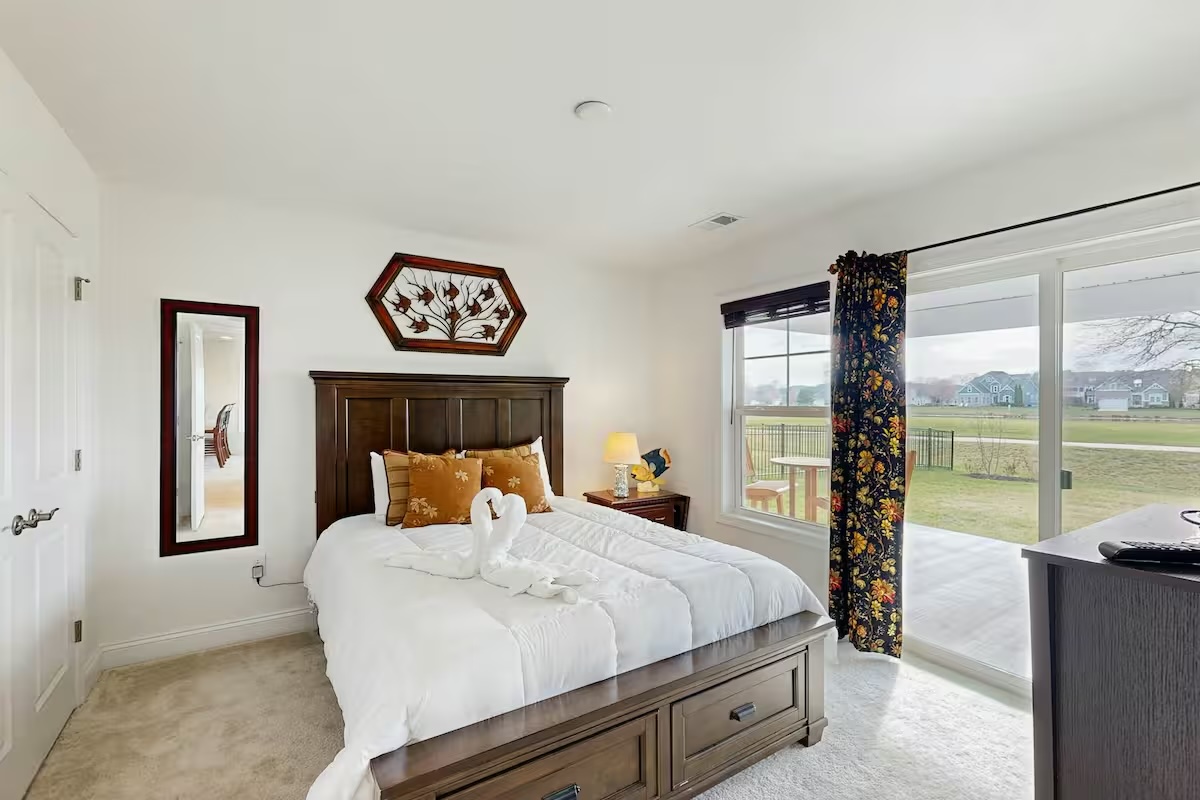 King bedroom with dark wood bed swan towels and garden view