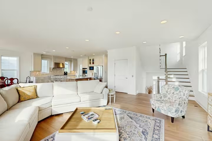 Open-concept living area with kitchen staircase and sectional sofa