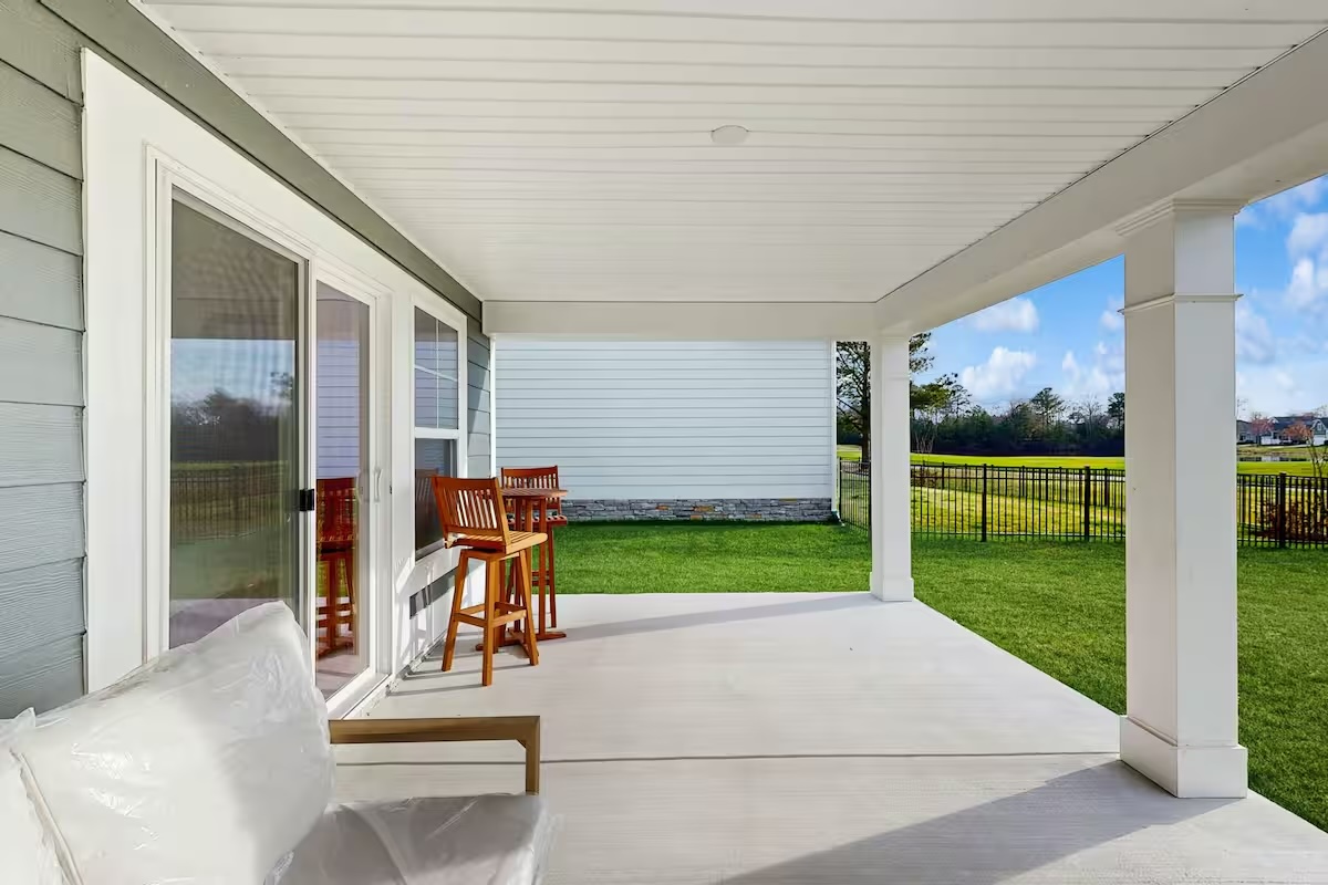 Covered porch with seating overlooking green yard