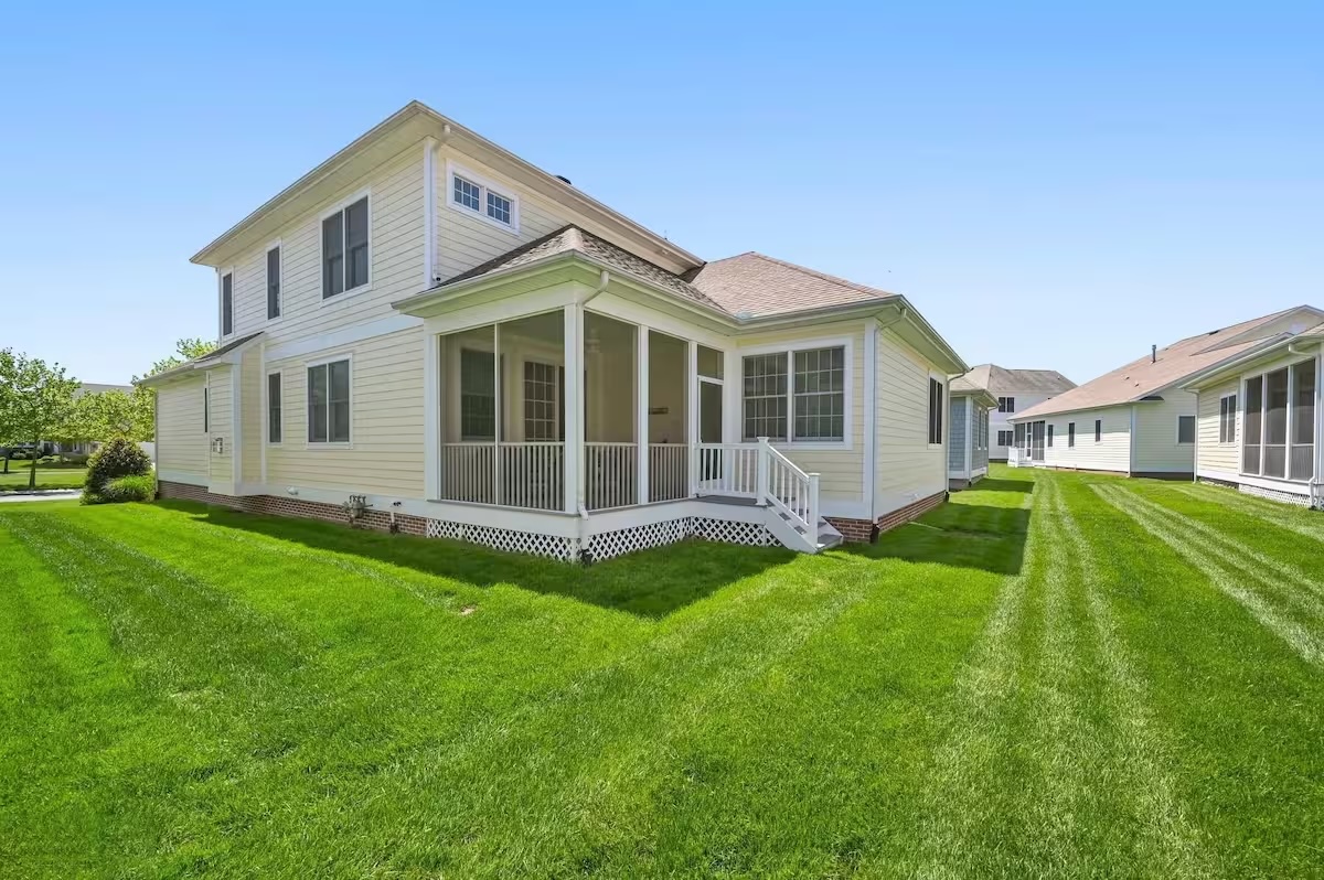 Bayside home exterior with screened porch and green lawn