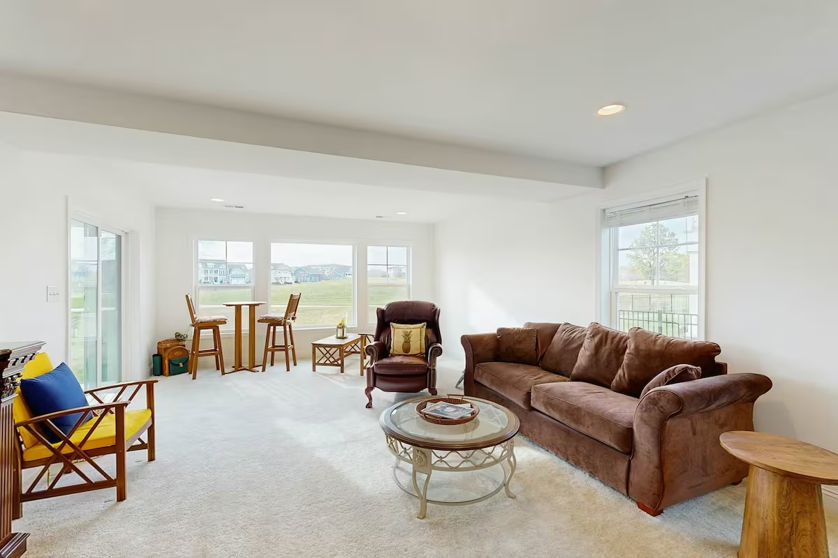 Sunlit lounge with brown sofa recliner and community views