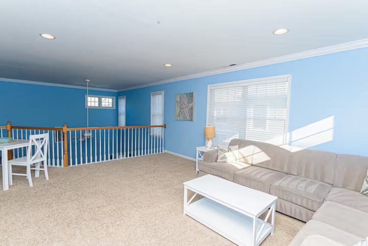 Blue living room loft with sectional sofa and starfish art