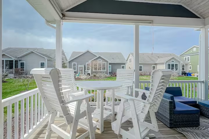 Screened porch with white dining set and neighborhood views
