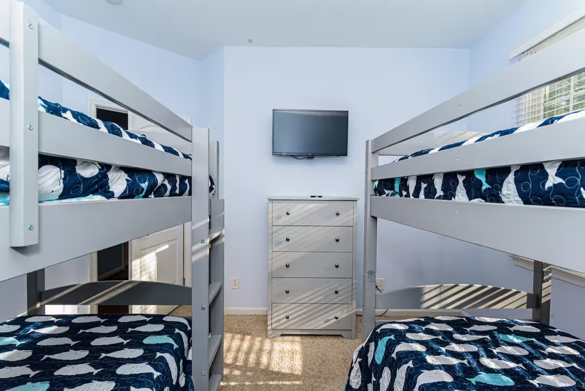 Bunk bed room with whale bedding and wall-mounted TV
