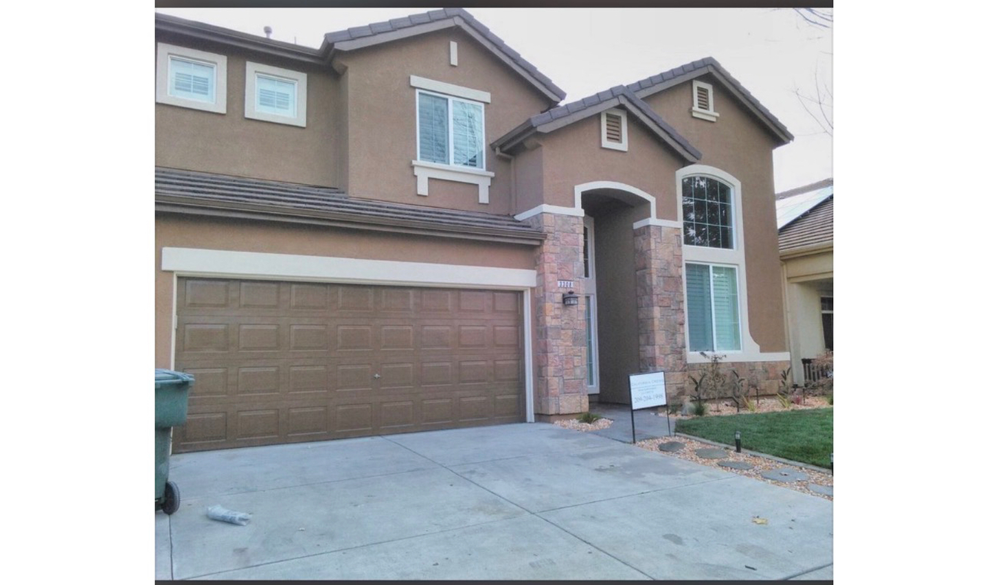 Exterior painting - two-story stucco home with stone accents in Central Valley