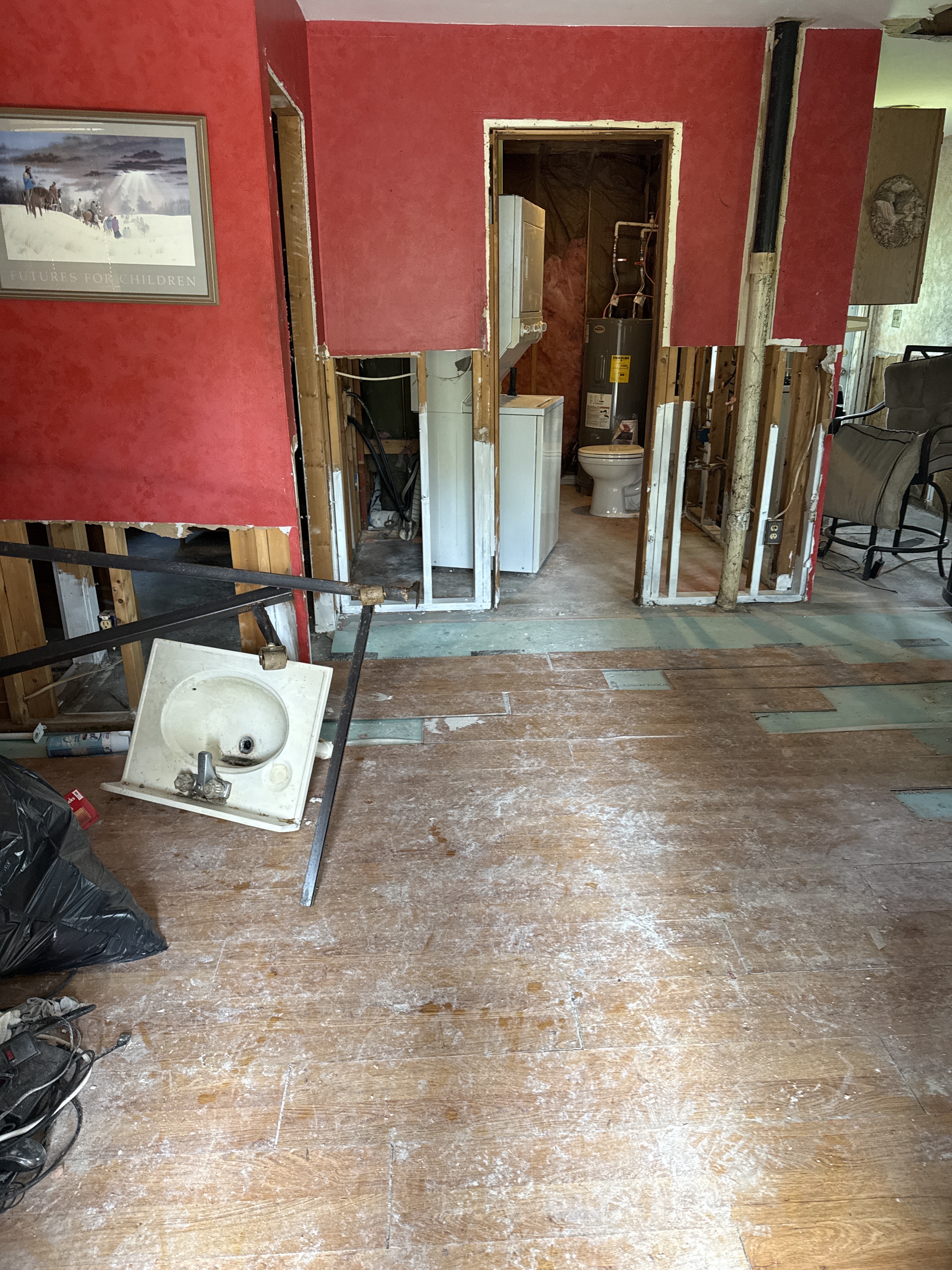 Remediated hallway area after drywall removal — clean framing exposed, containment removed, concrete floor visible