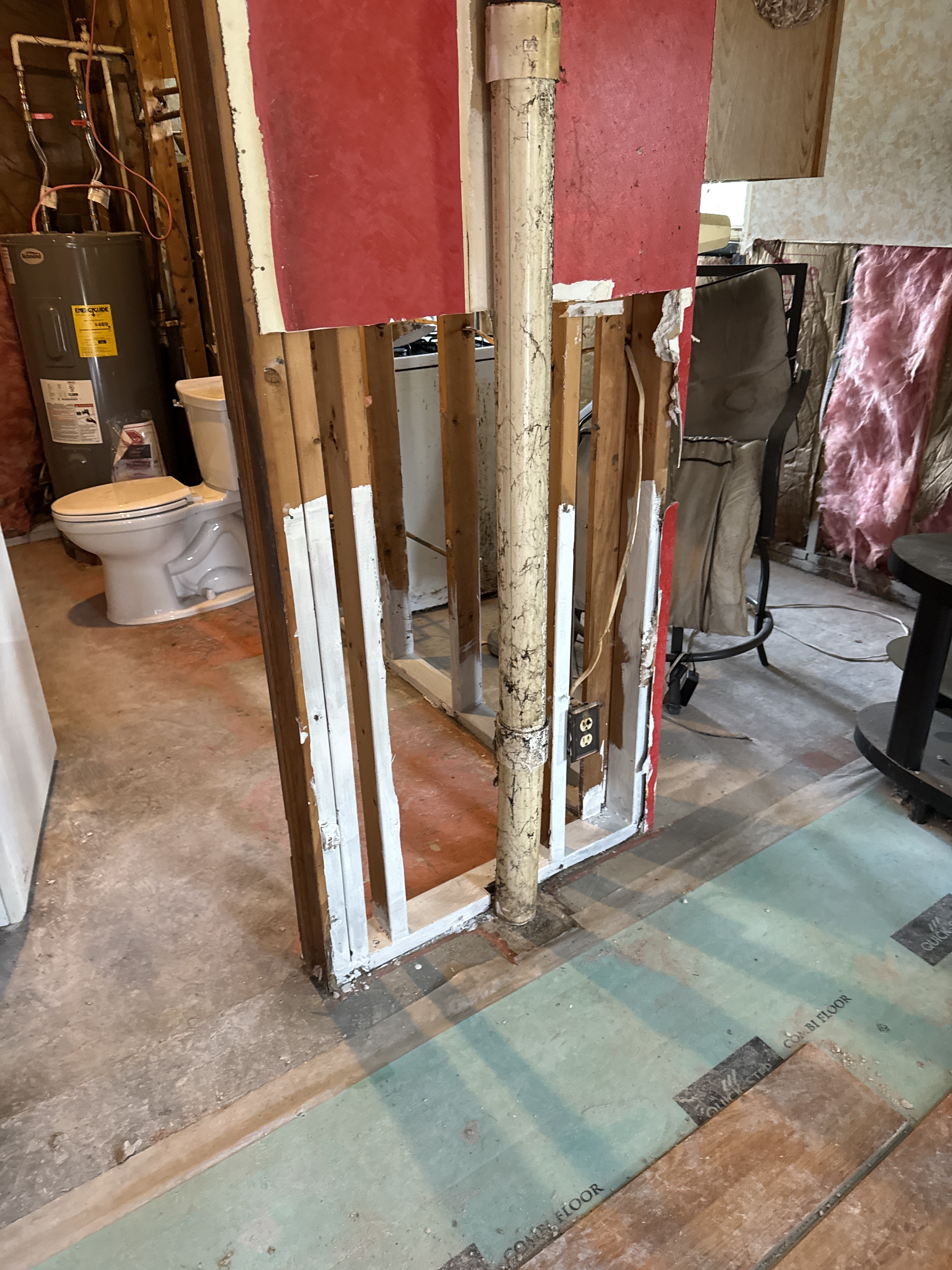 Remediated room after drywall and insulation removal — exposed R-19 insulation bays visible, clean framing throughout