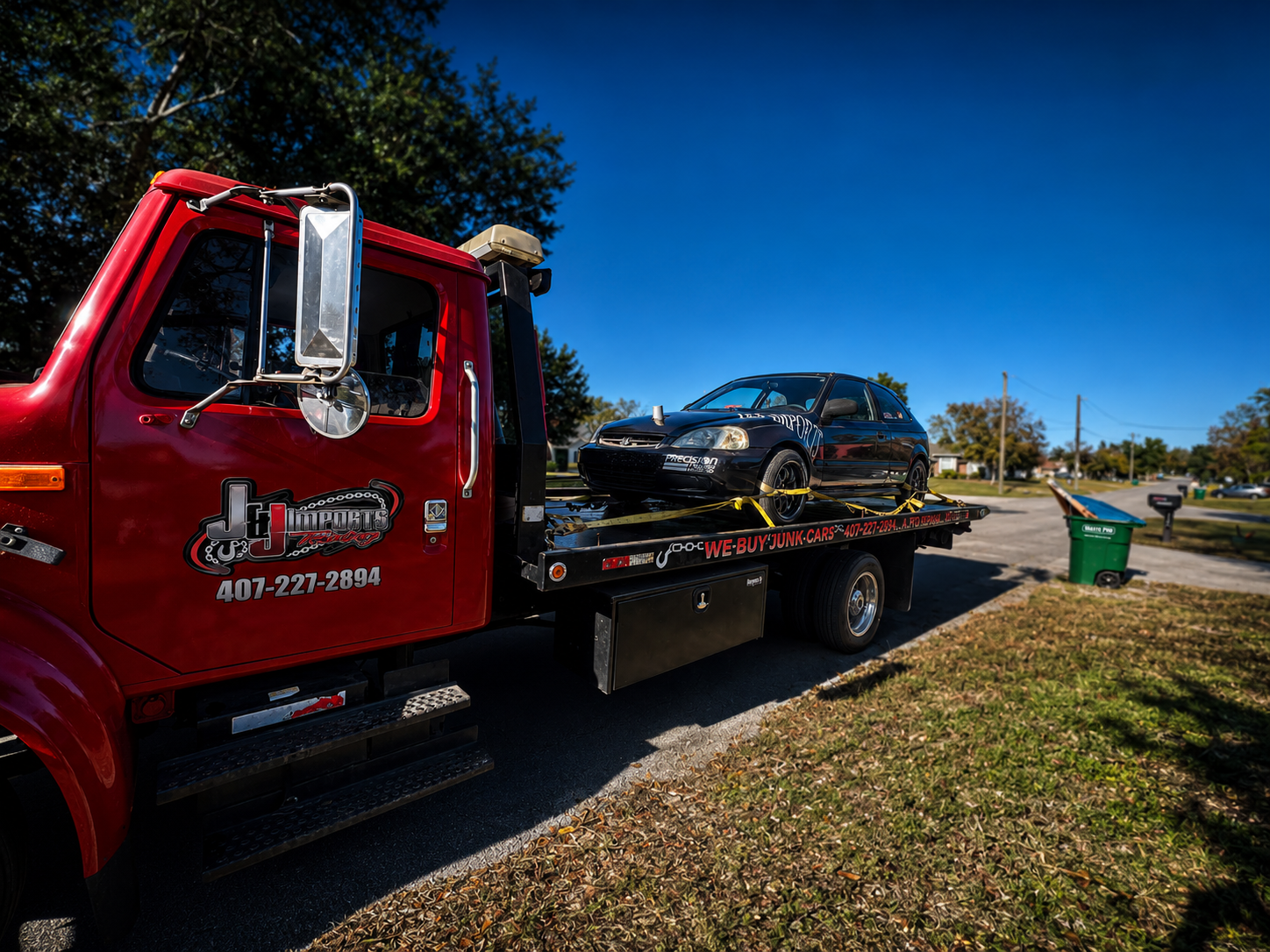 J&J Imports tow truck hauling a black Civic in residential neighborhood