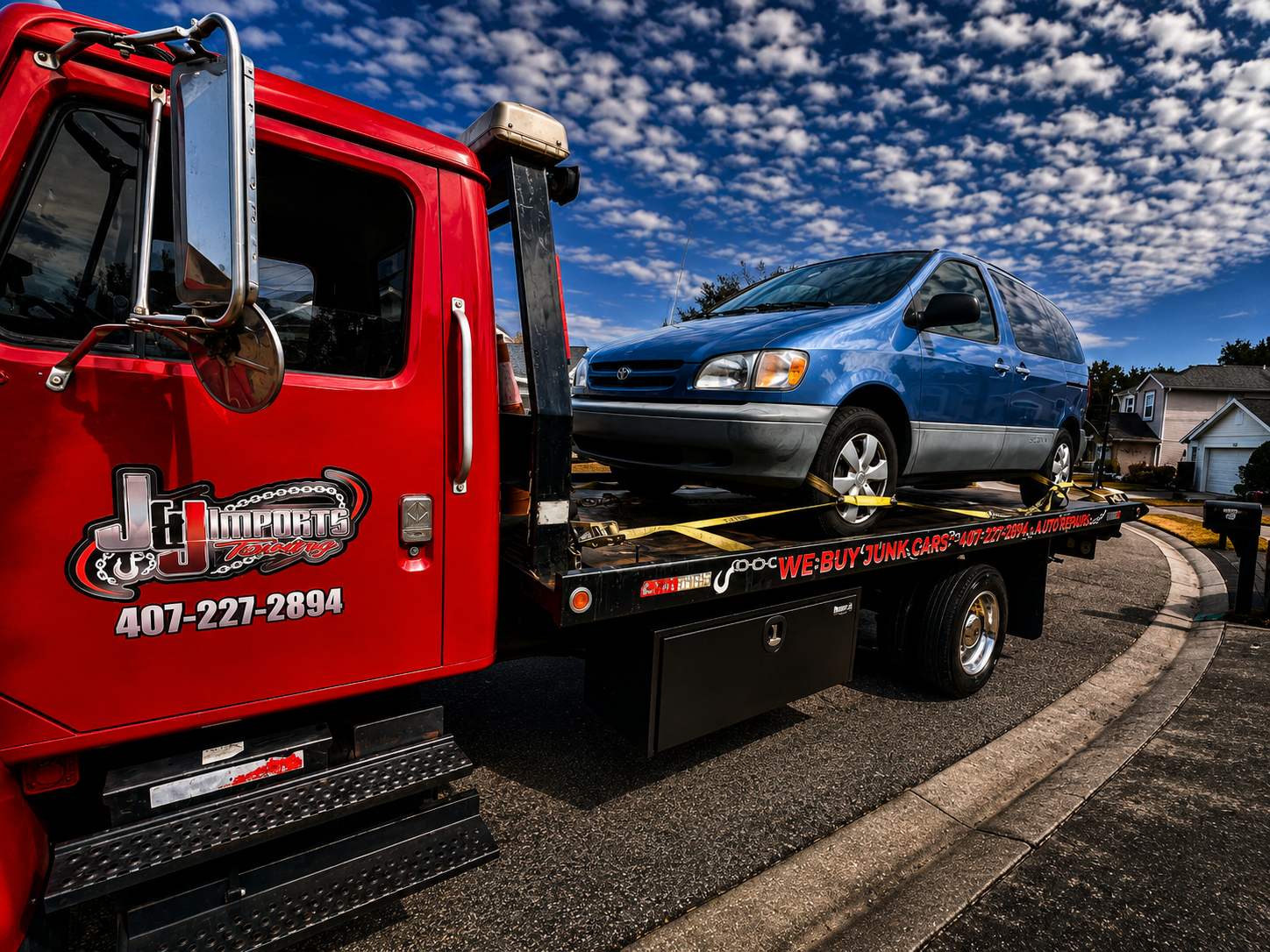 J&J Imports tow truck hauling a blue Toyota Sienna