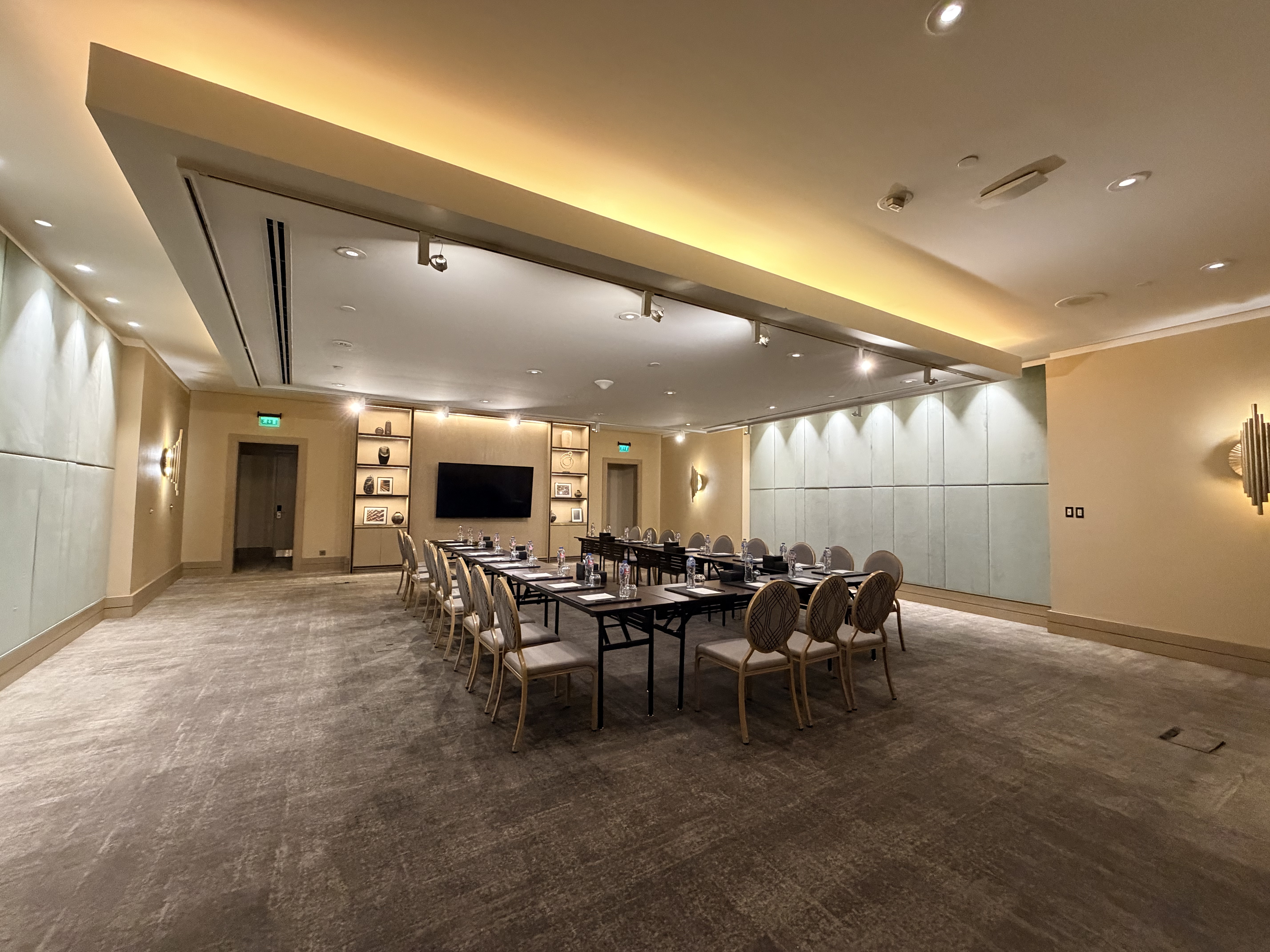 Premium meeting room with U-shaped table setup and elegant warm lighting