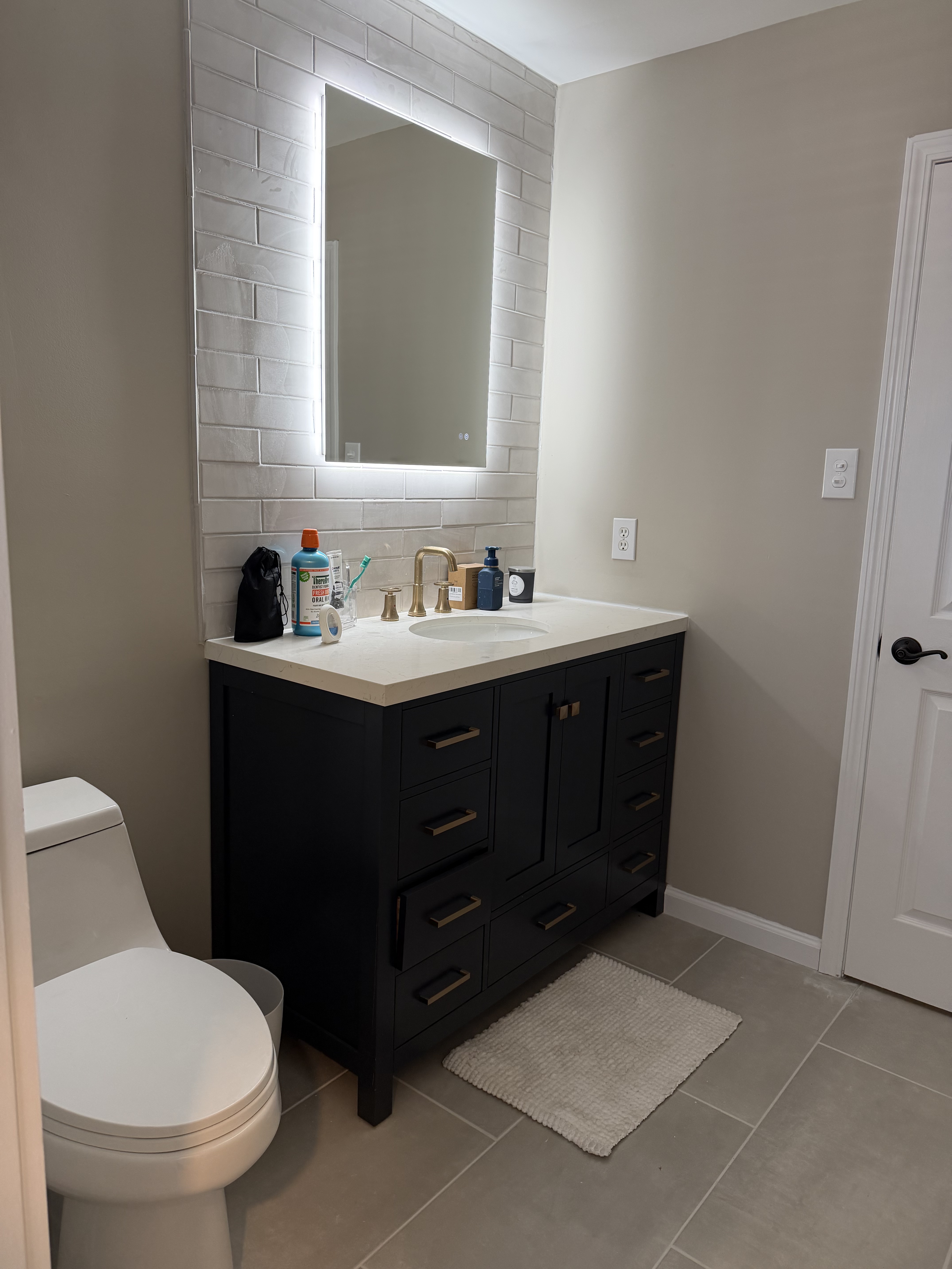 Vanity and mirror with subway tile backsplash