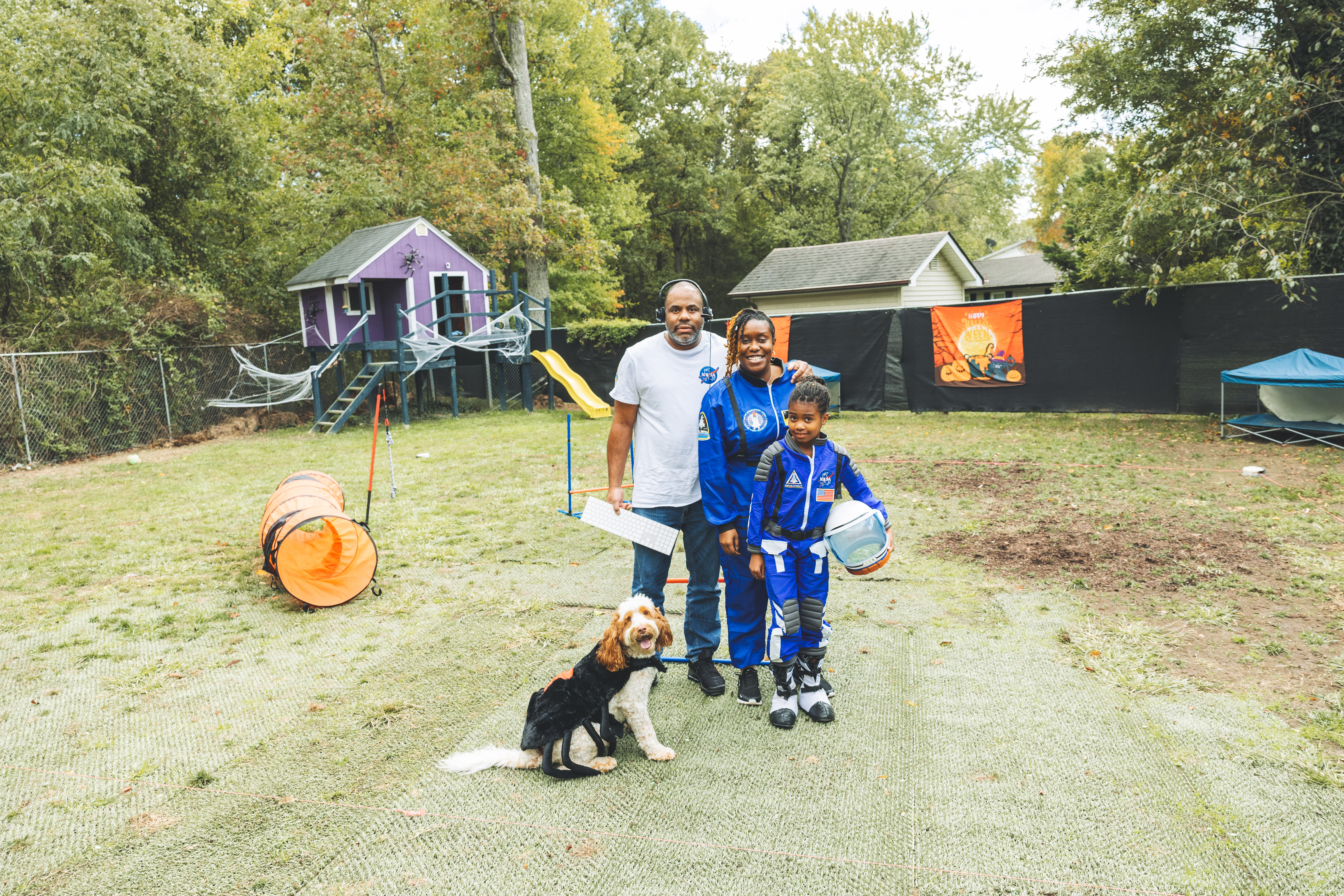 Family with their dog in costumes at Waggy World event