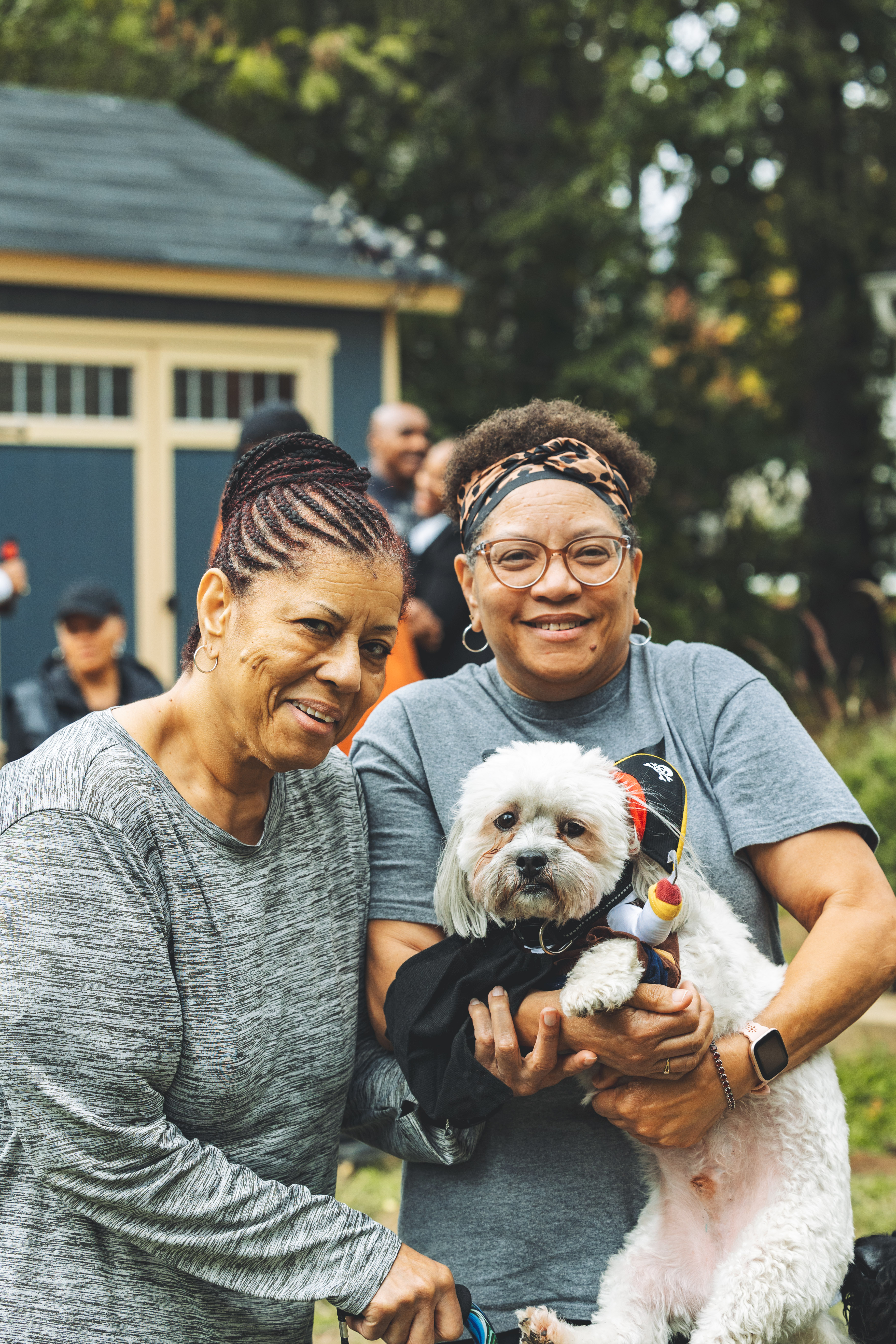 Pet parents posing with their pup in pirate costume