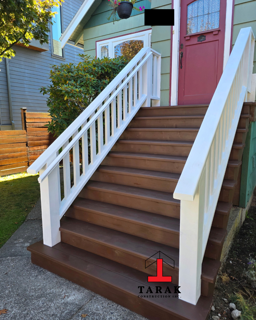 Sean's custom front entrance stairs with white railing by Tarak Construction