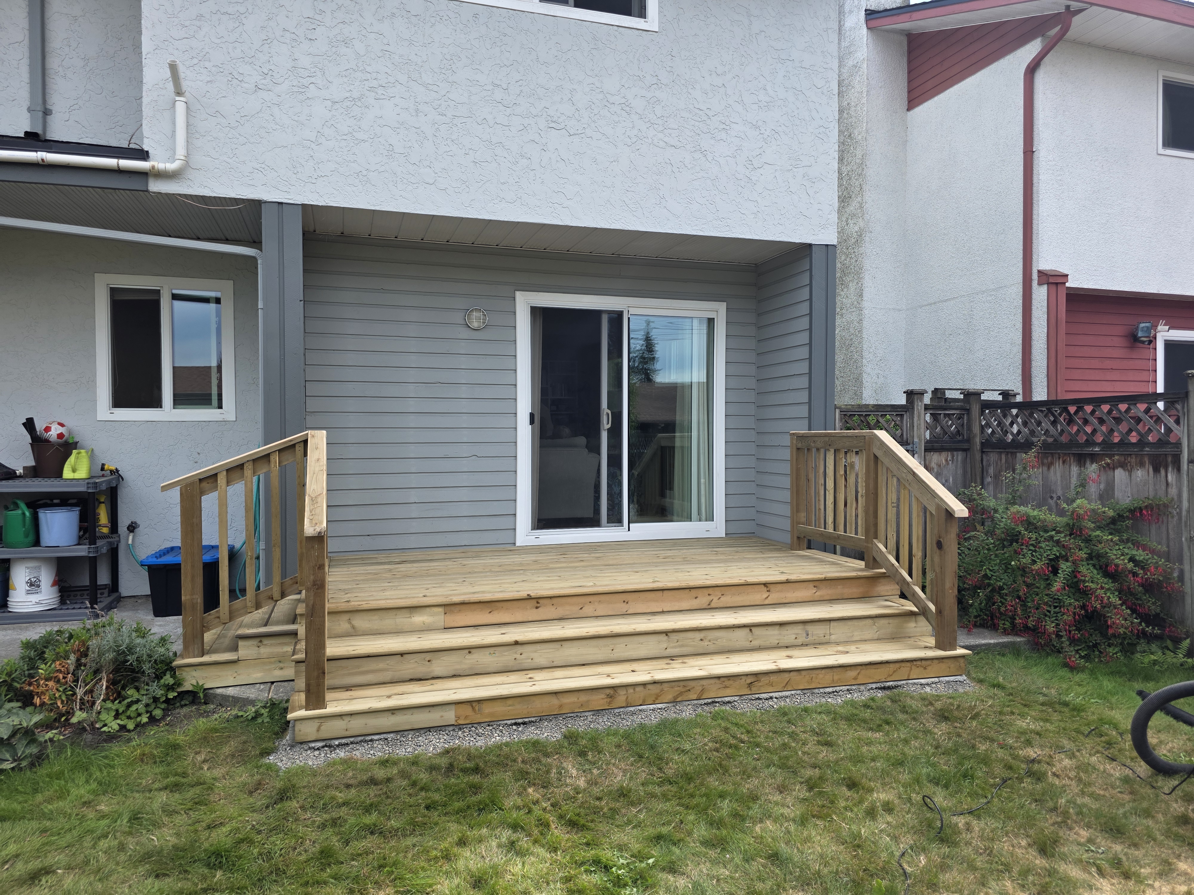 Paul's back sliding door deck with stairs and handrails by Tarak Construction