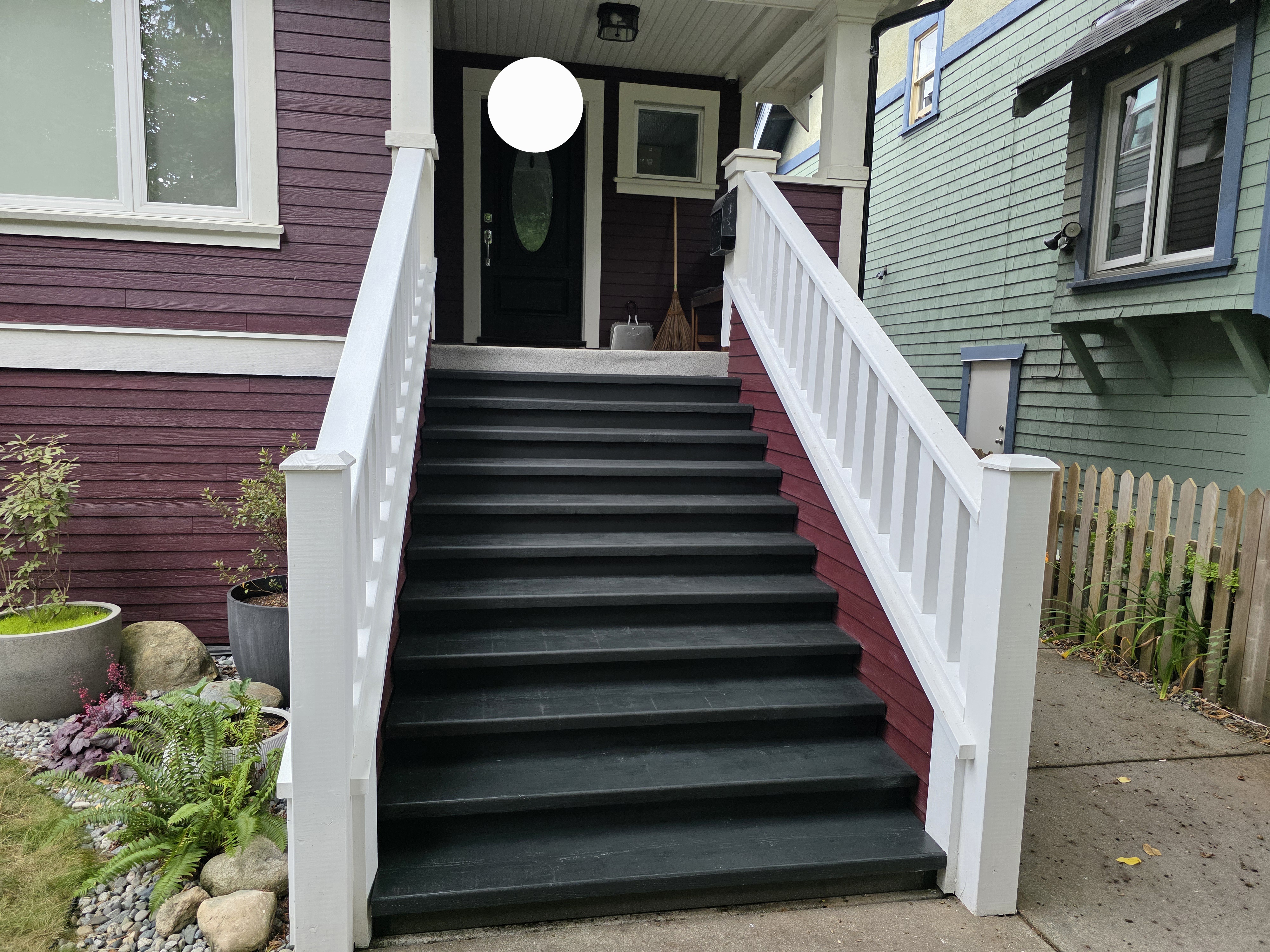 Louis's front entrance stairs with dark treads and white railing by Tarak Construction