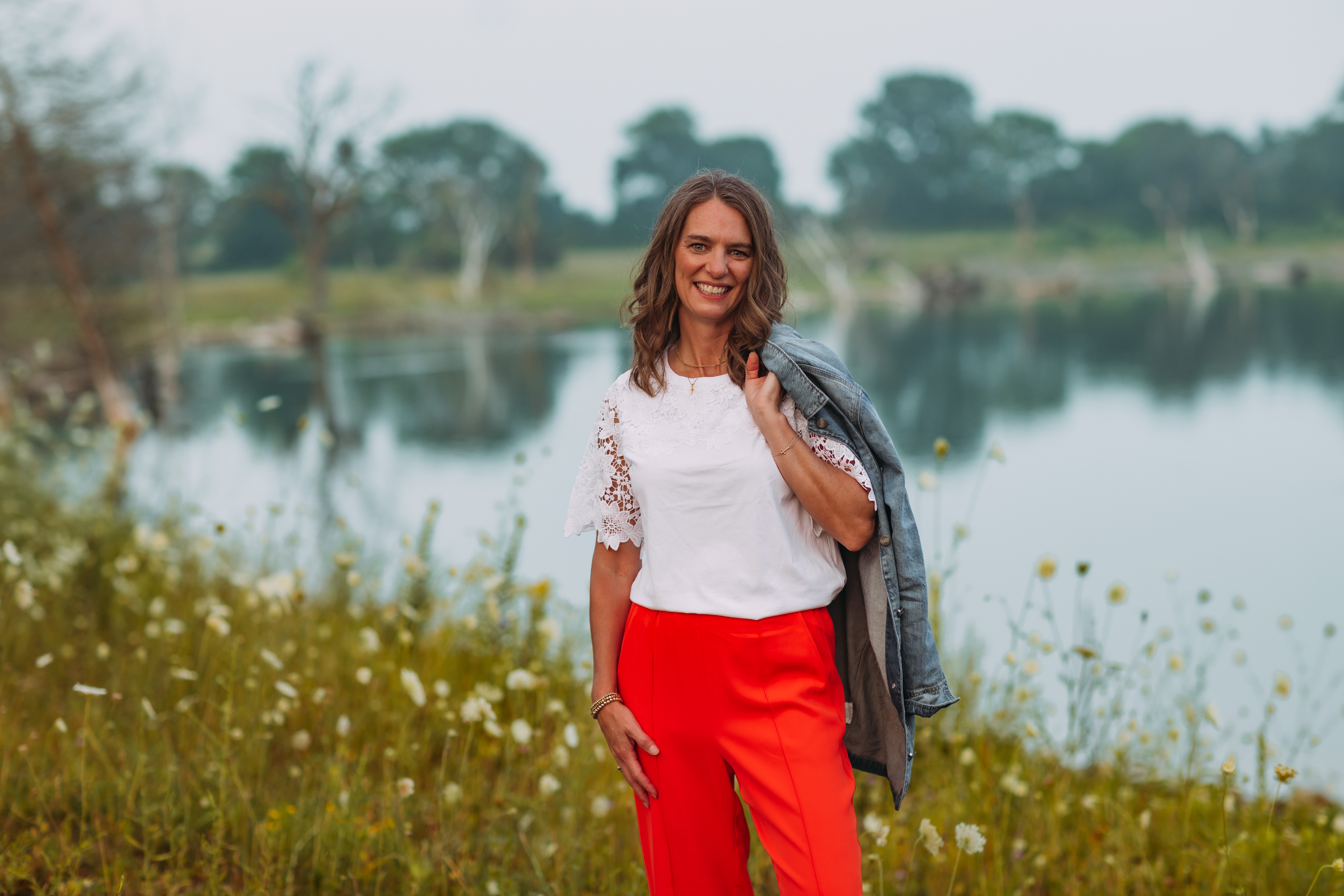 Jesi smiling outdoors by the lake