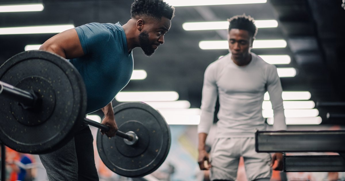 Two men training in a gym — the cohort, identity and rhythm installed together