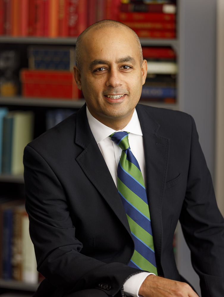 Executive headshot with bookshelf background