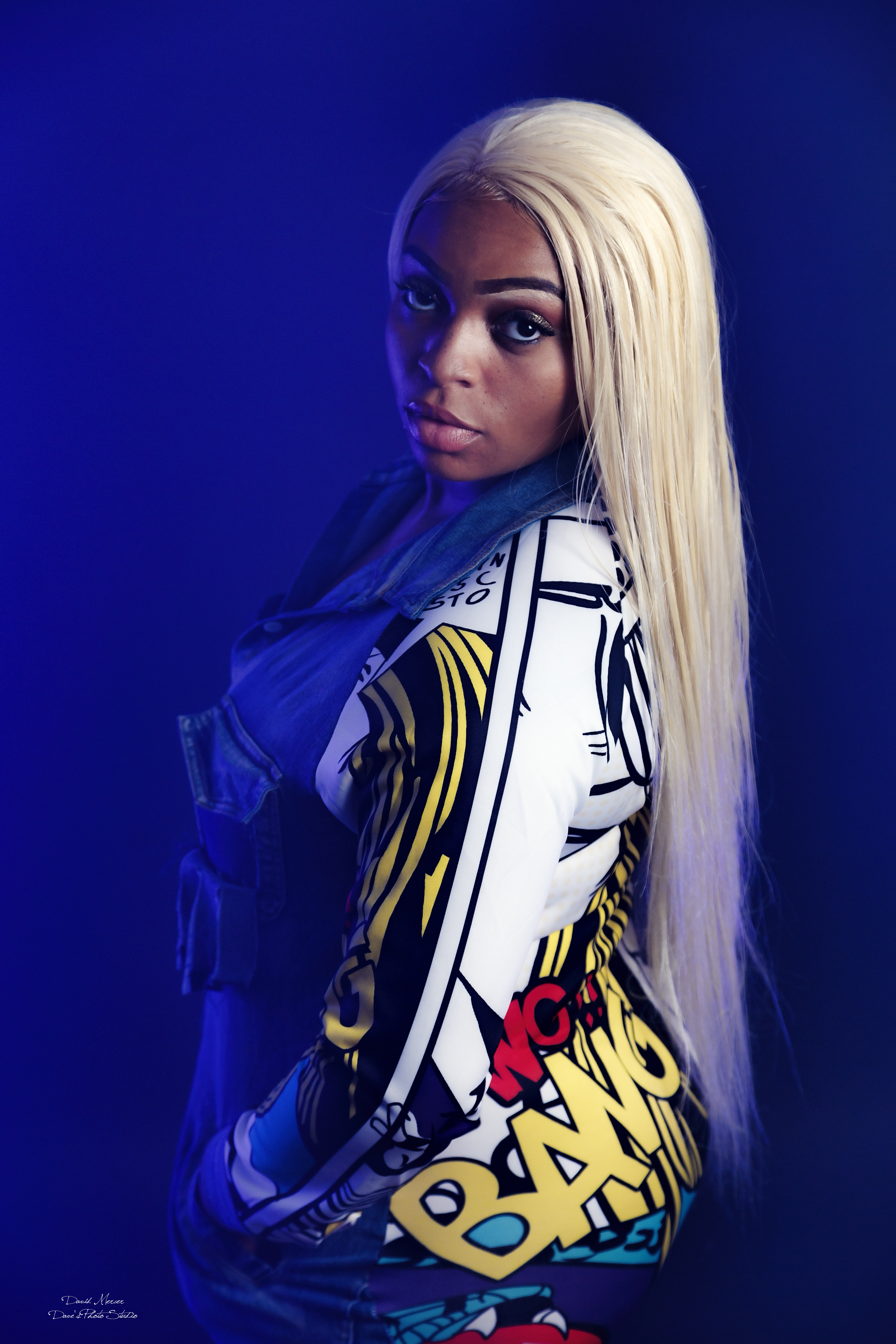 Bold editorial fashion portrait with platinum hair against blue background — IDT Photo Aurora IL