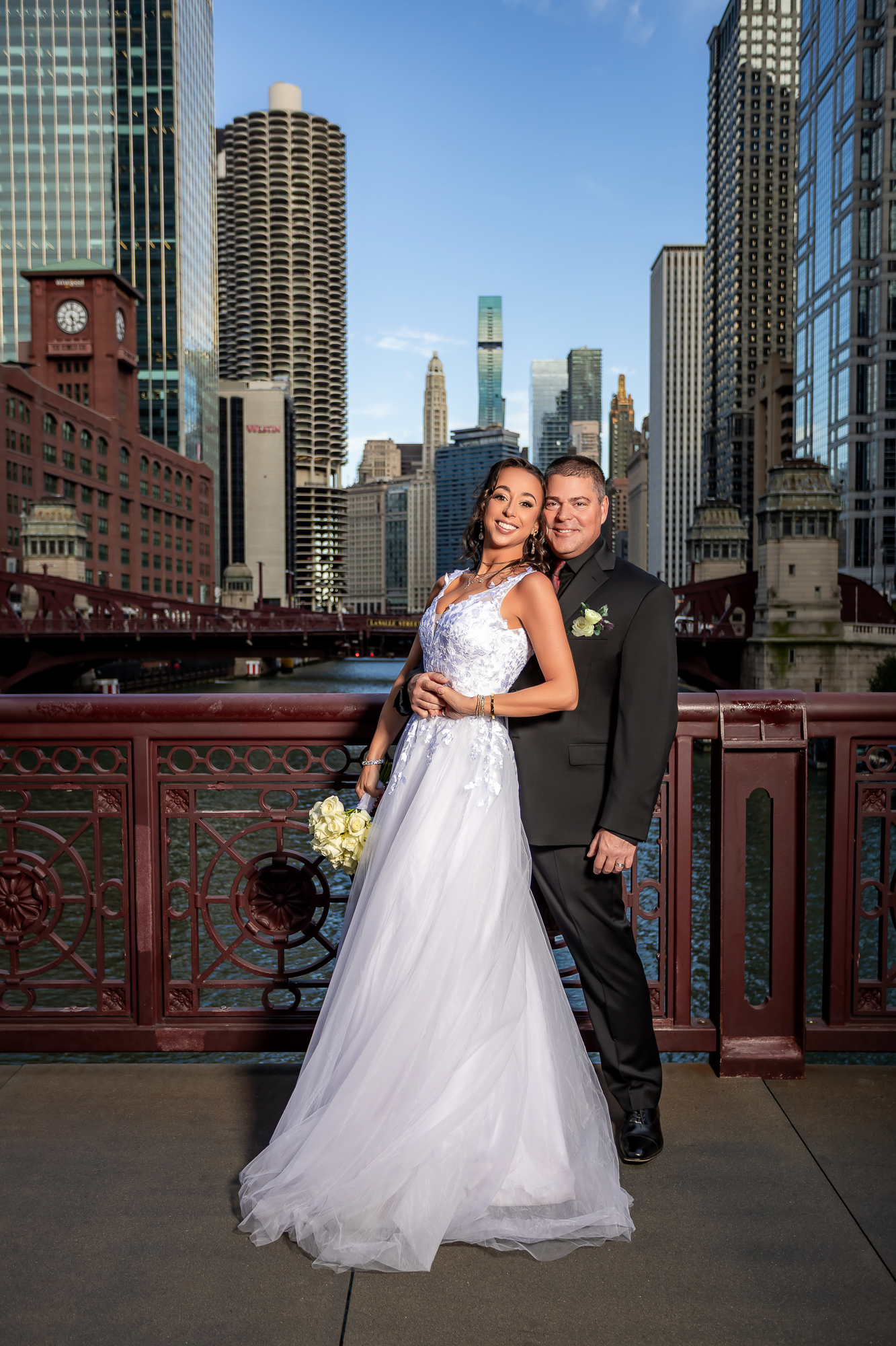 Bride and groom smiling together on Chicago bridge with skyline and river — IDTPhoto wedding portrait