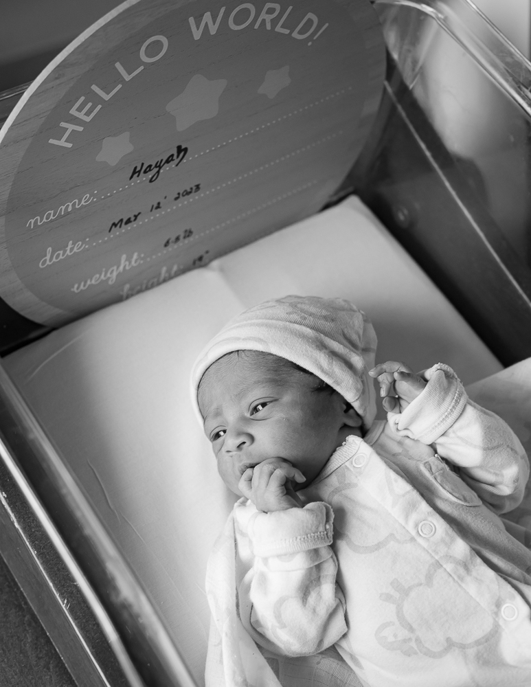 Fresh 48 — newborn Hayah in hospital bassinet with Hello World birth announcement board
