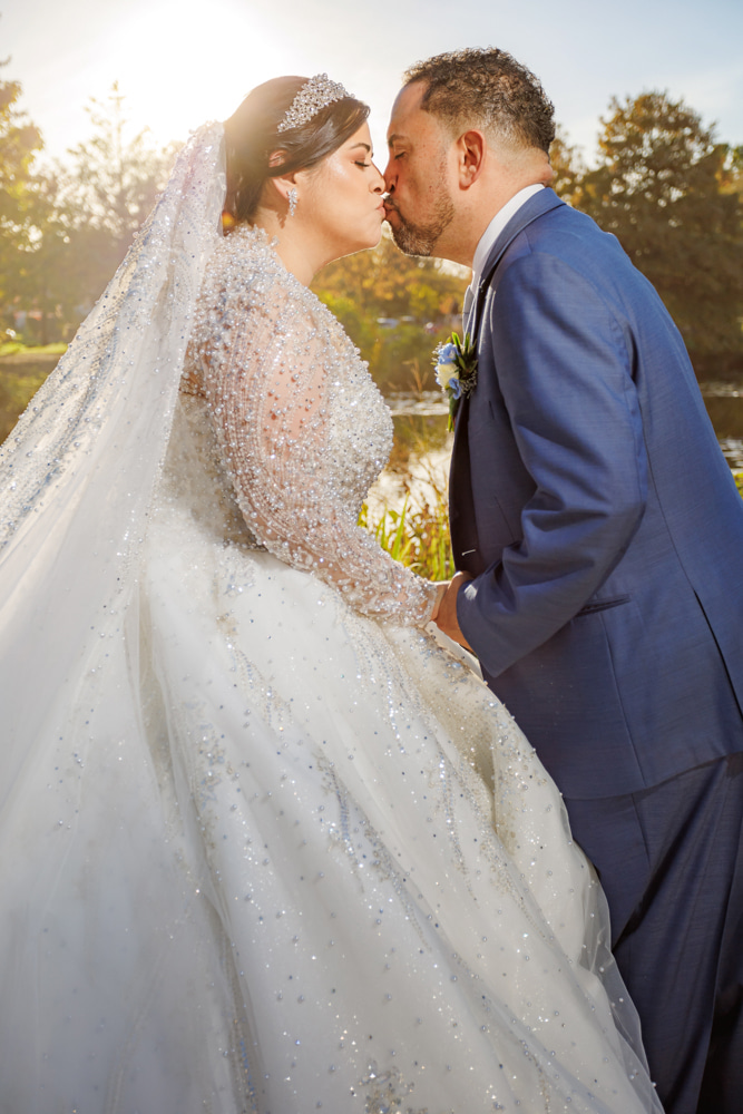 Bride and groom kissing at golden hour with beaded crystal ball gown catching the sunlight — IDTPhoto wedding photography