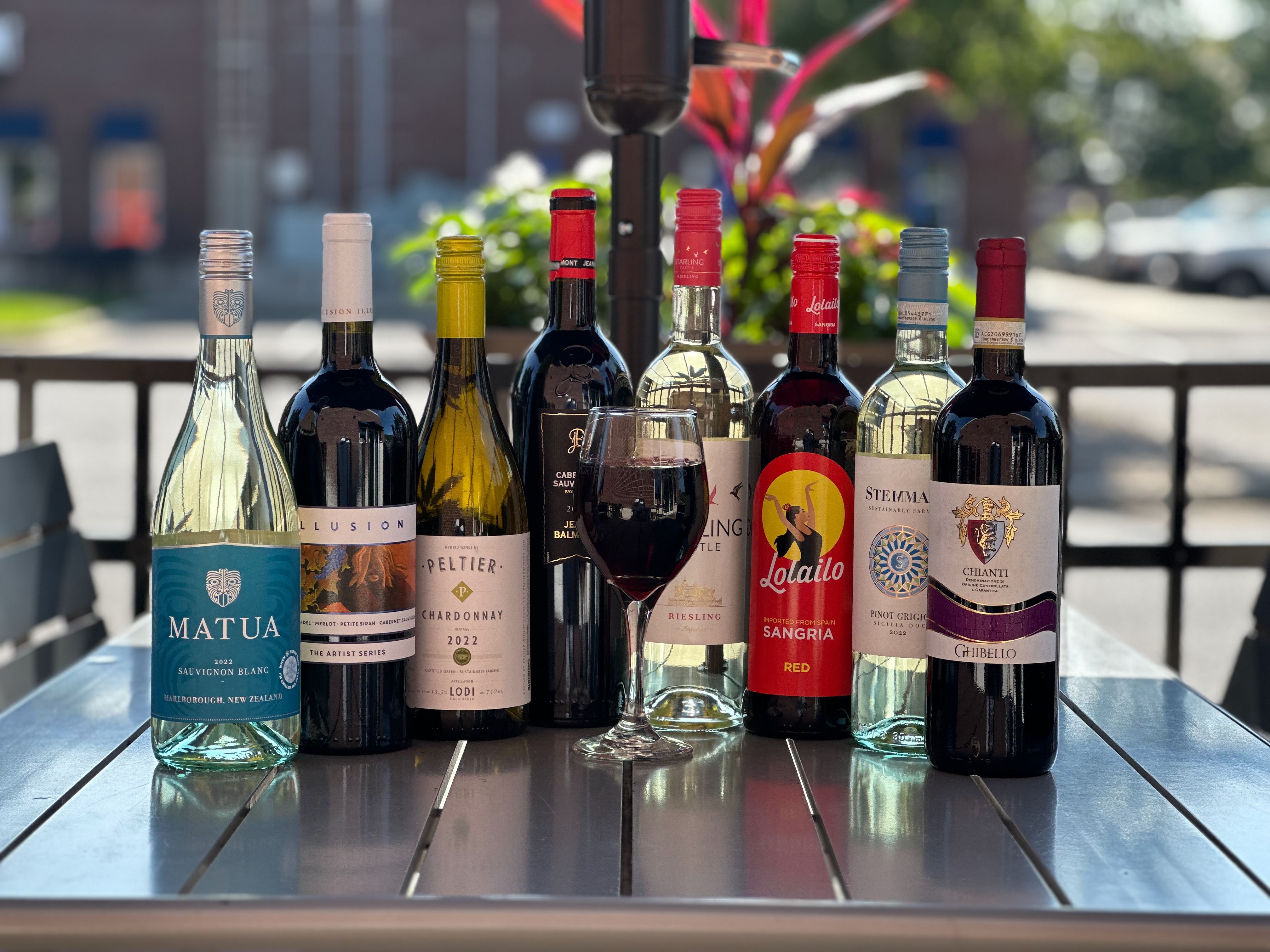 Curated wine bottle lineup on the patio at Vortex