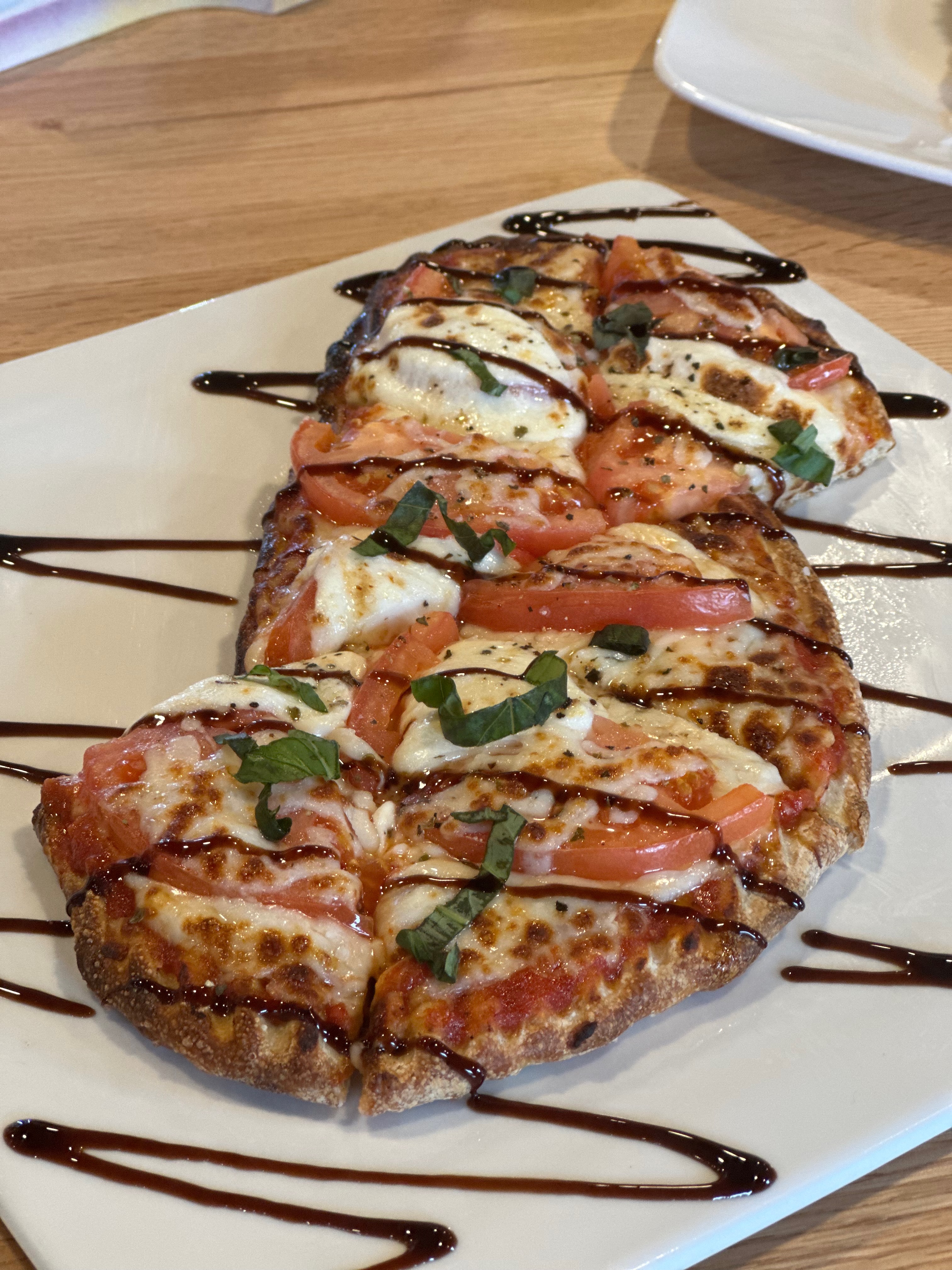 Margherita flatbread with balsamic drizzle and fresh basil