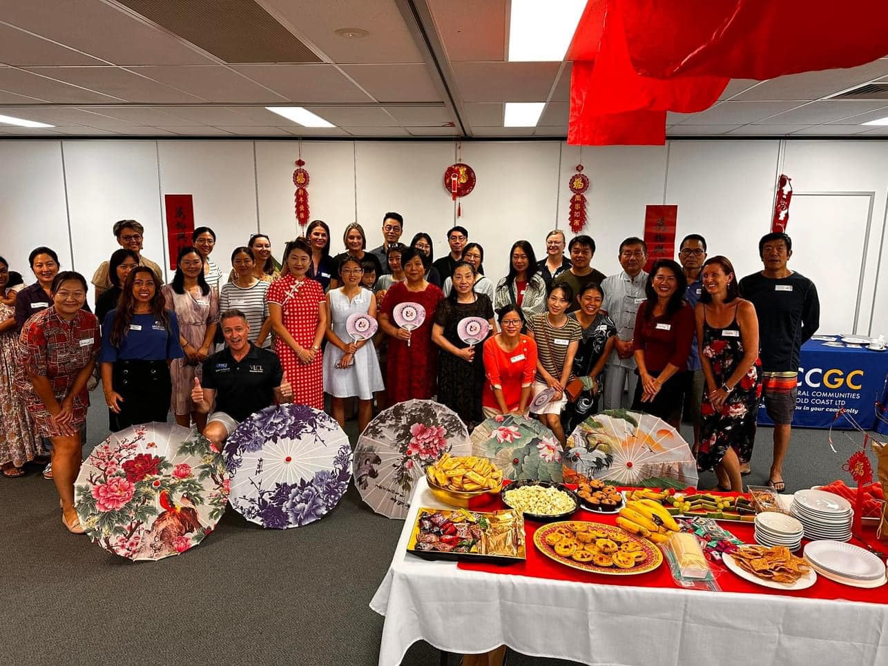 Community gathering at Sports House — a large group of community members celebrating together