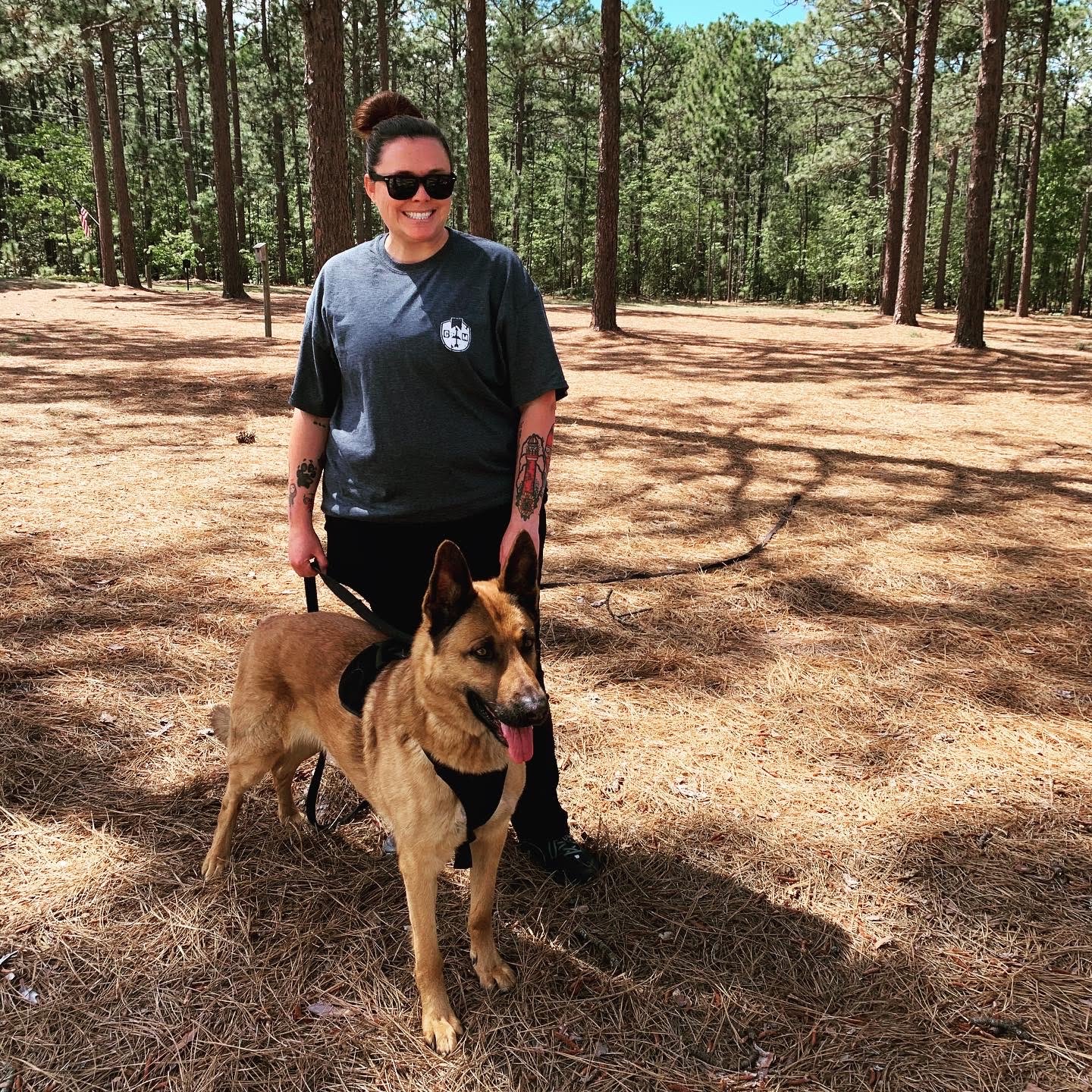 Christina Long training a German Shepherd in pine forest