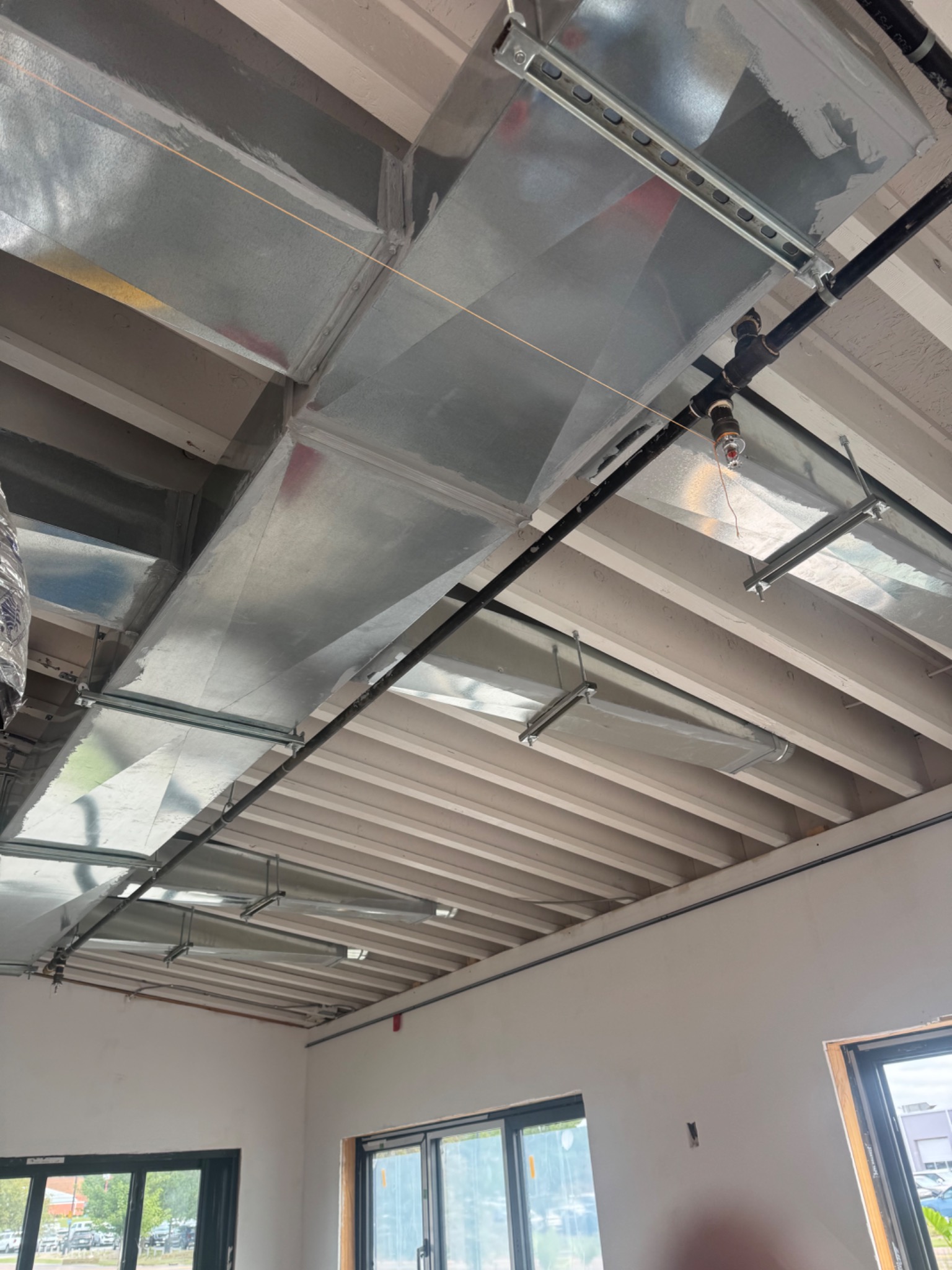 Galvanized duct system with trapeze hangers — restaurant build-out