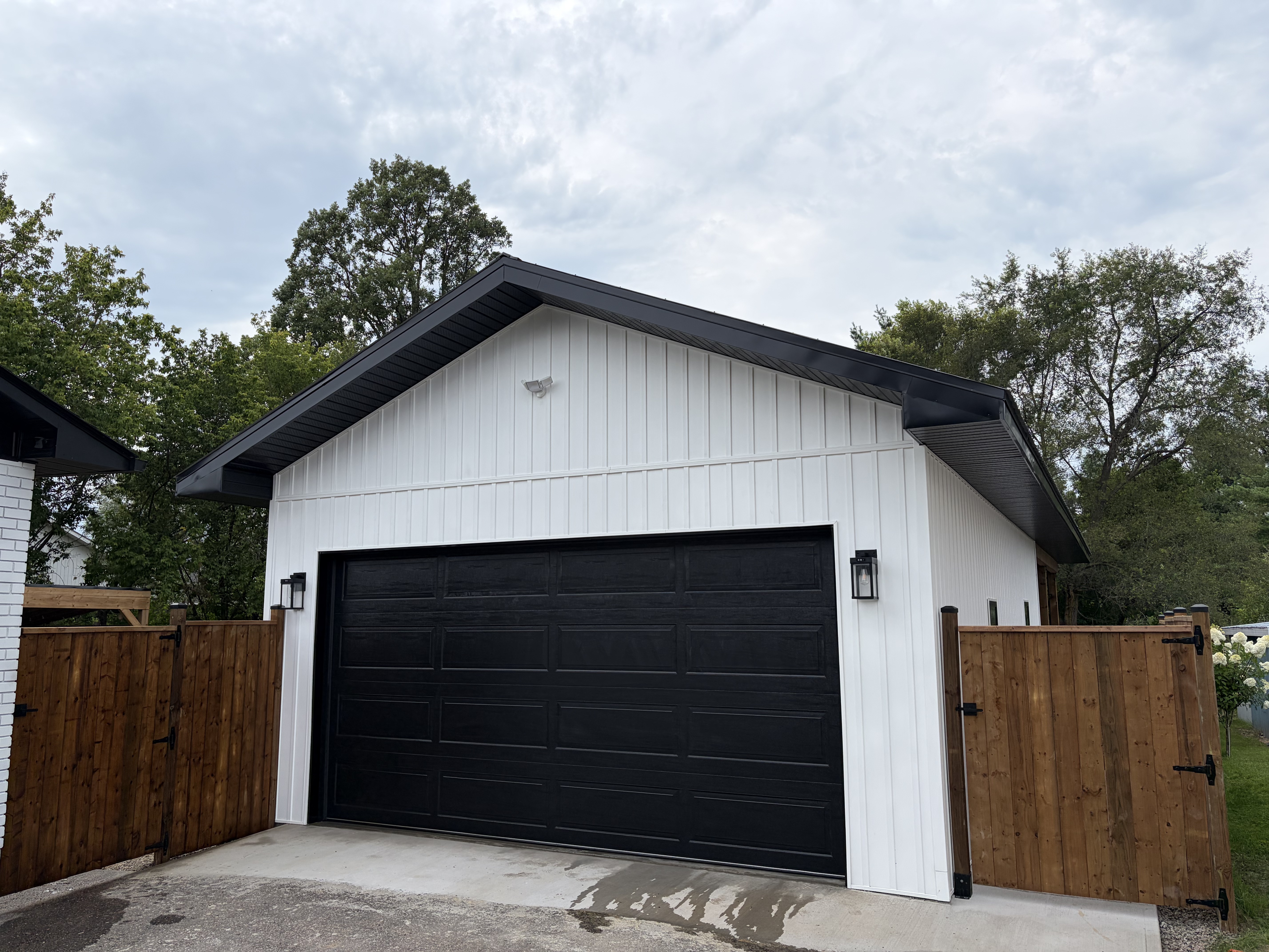 Custom garage exterior with white siding and black accents