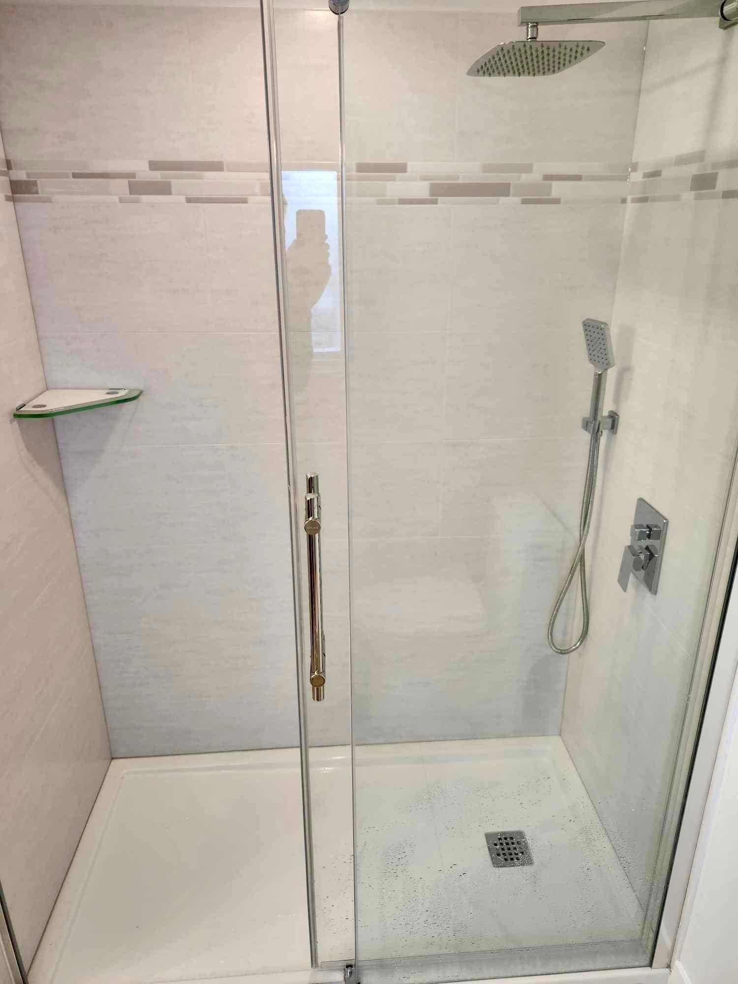 Walk-in shower with glass corner shelf