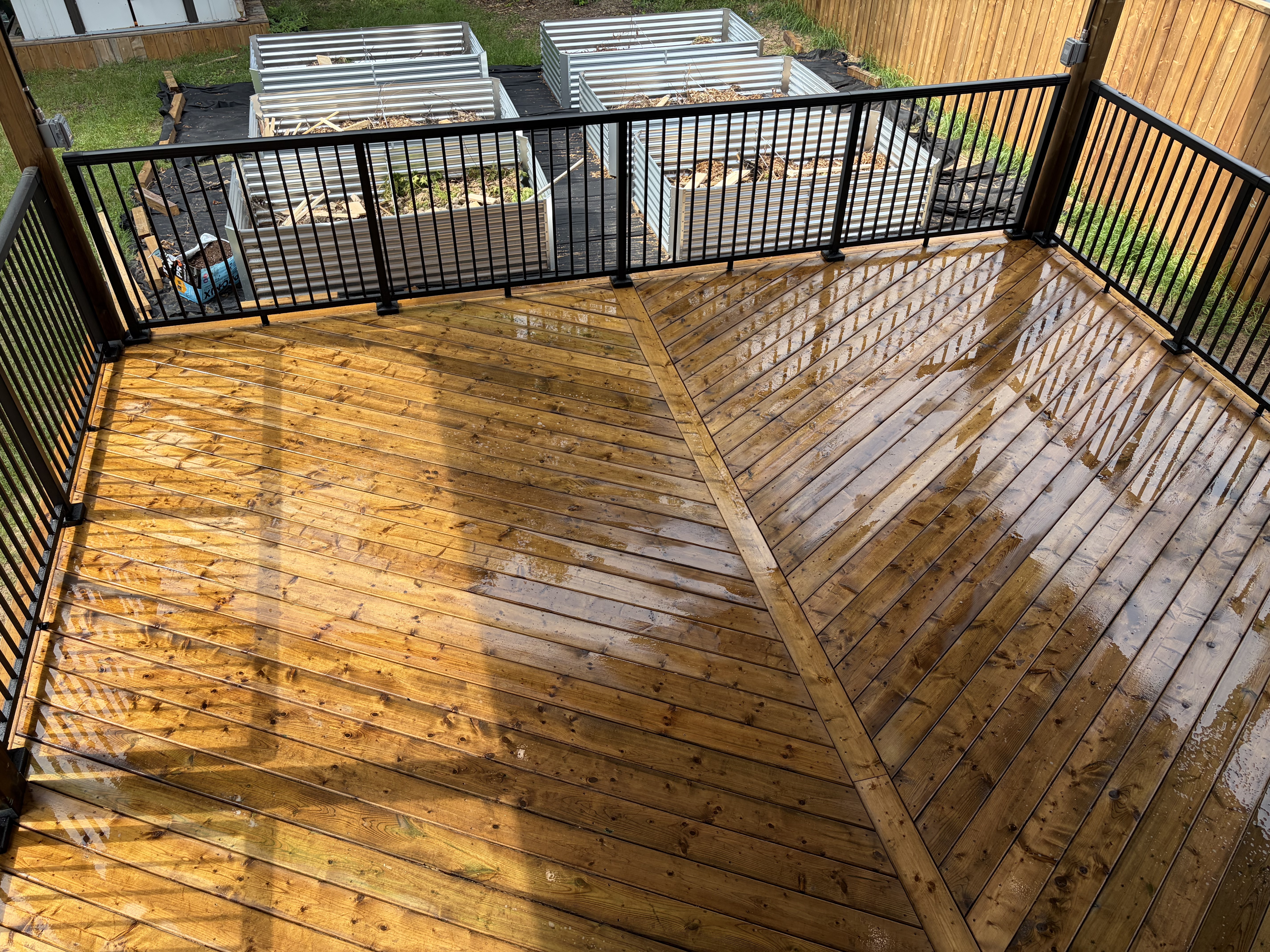 Covered deck herringbone pattern deck boards with black railing