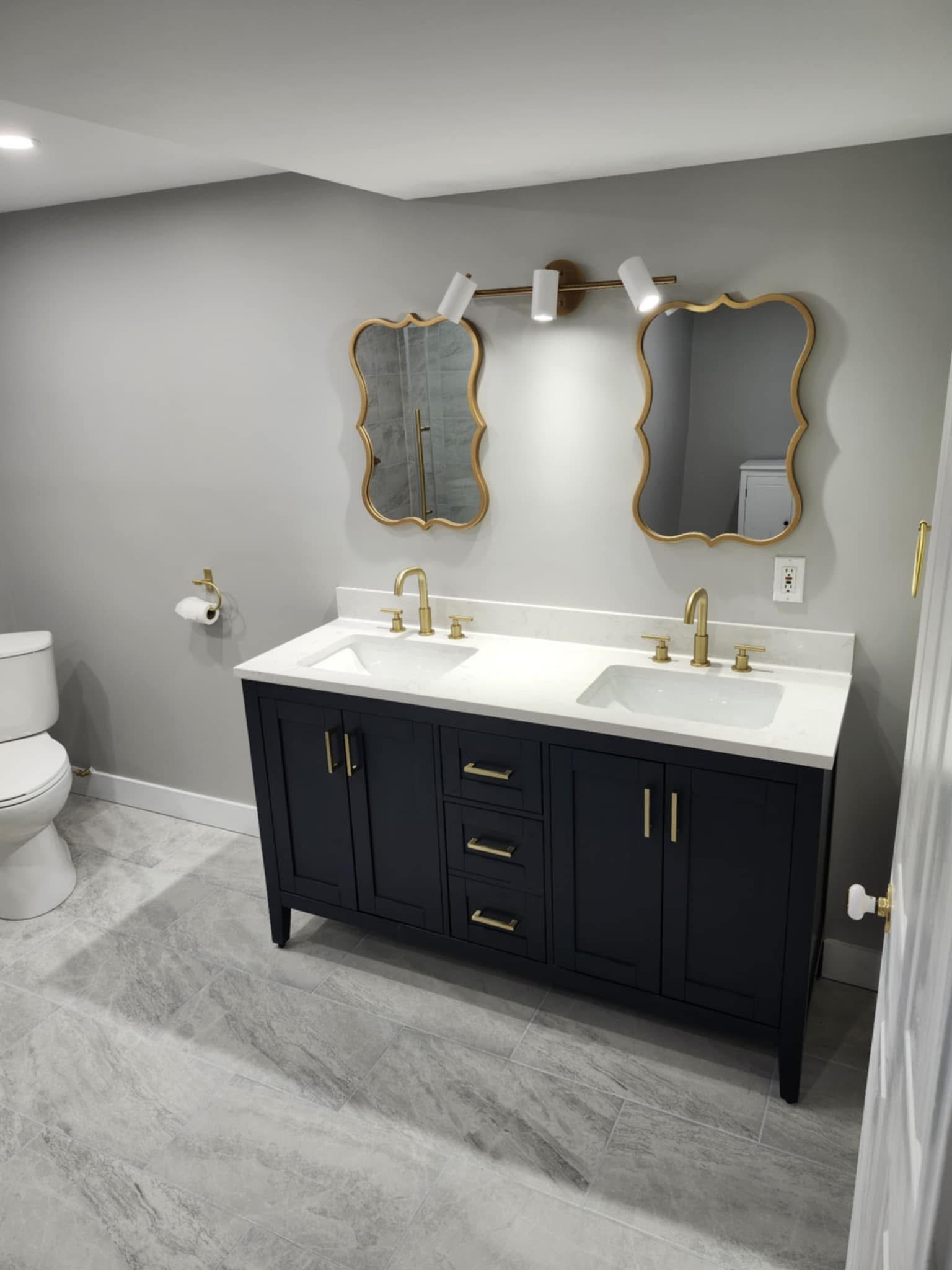 Bathroom vanity with gold fixtures and mirrors
