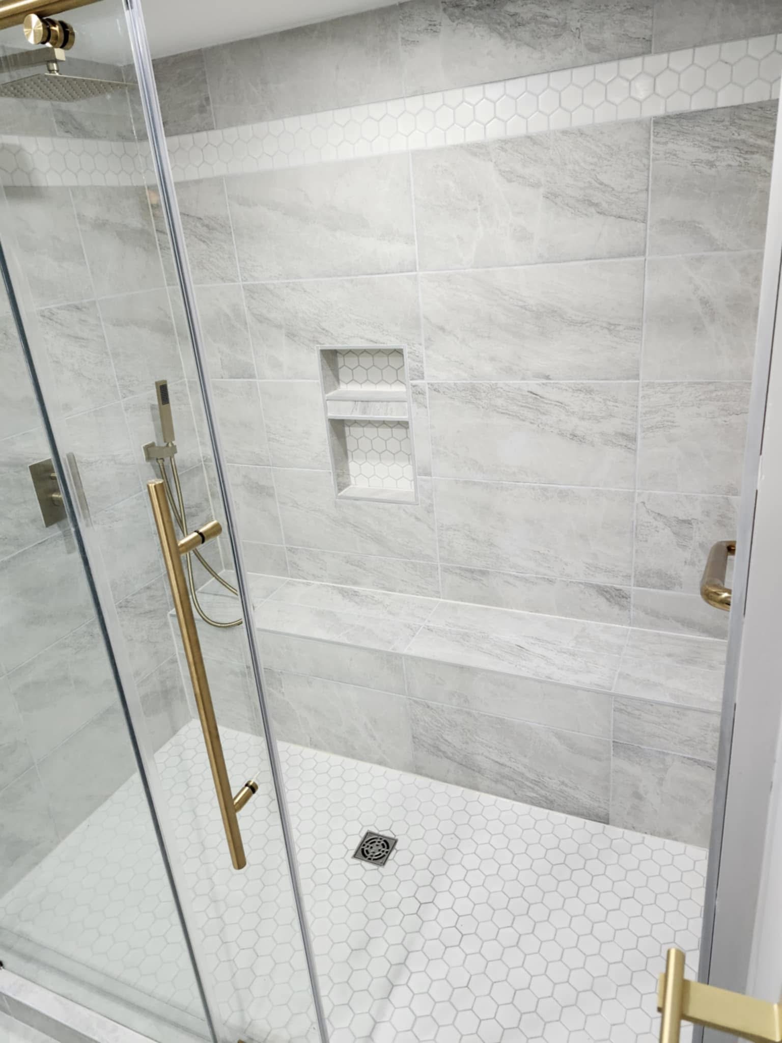 Walk-in shower with marble tile and gold hardware