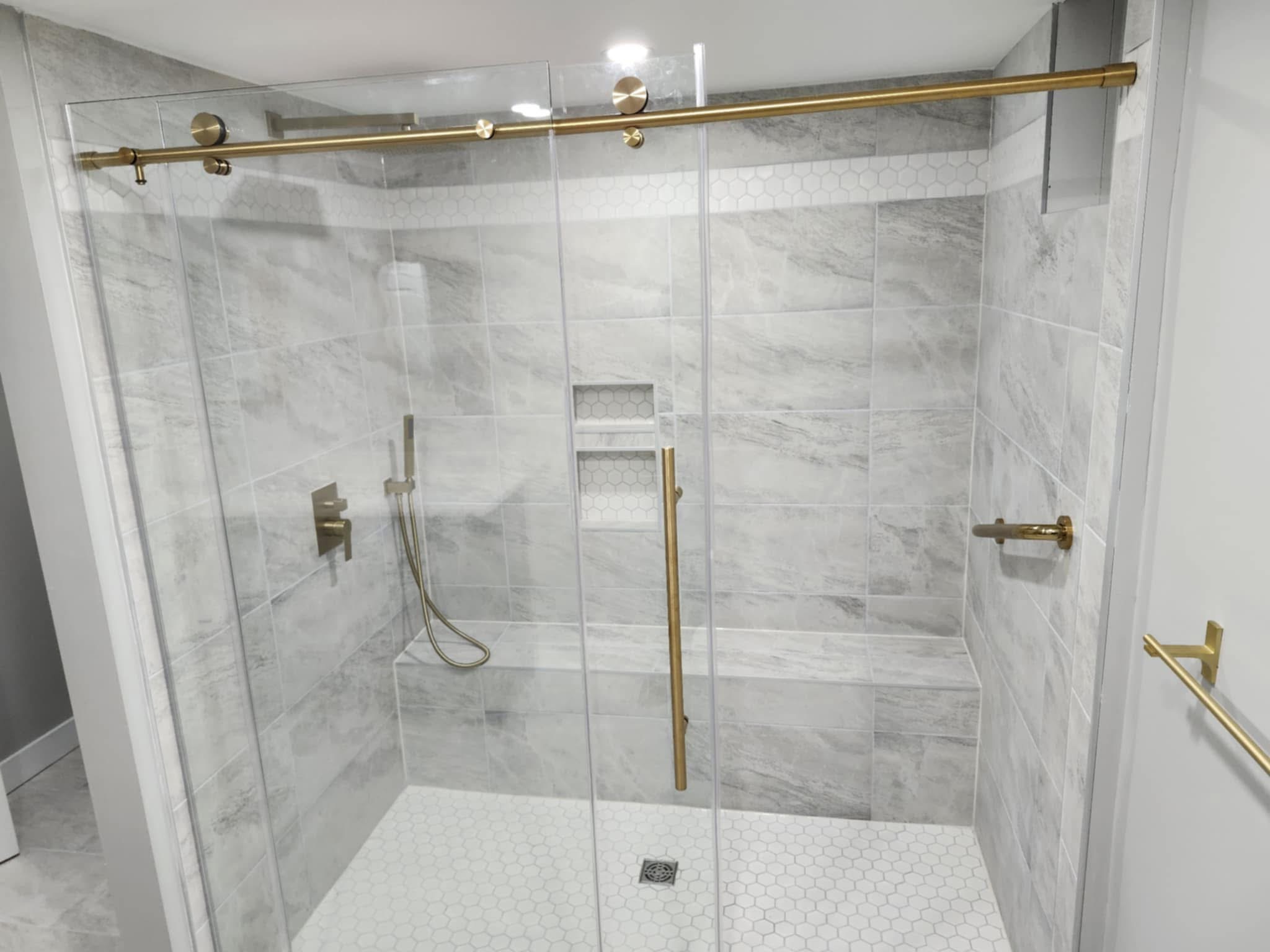 Glass shower enclosure with gold accents