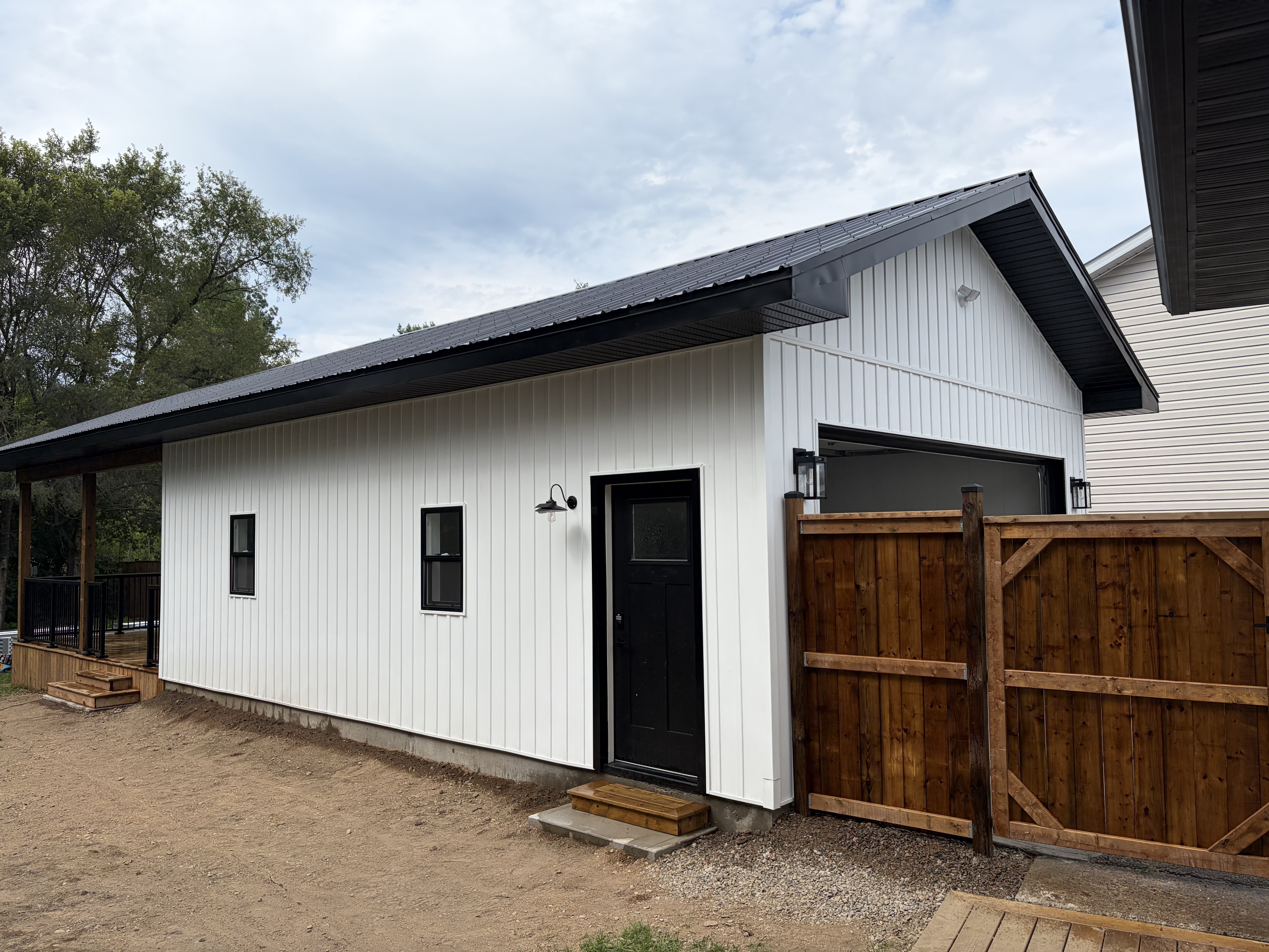 Custom garage side view with black door and gooseneck light