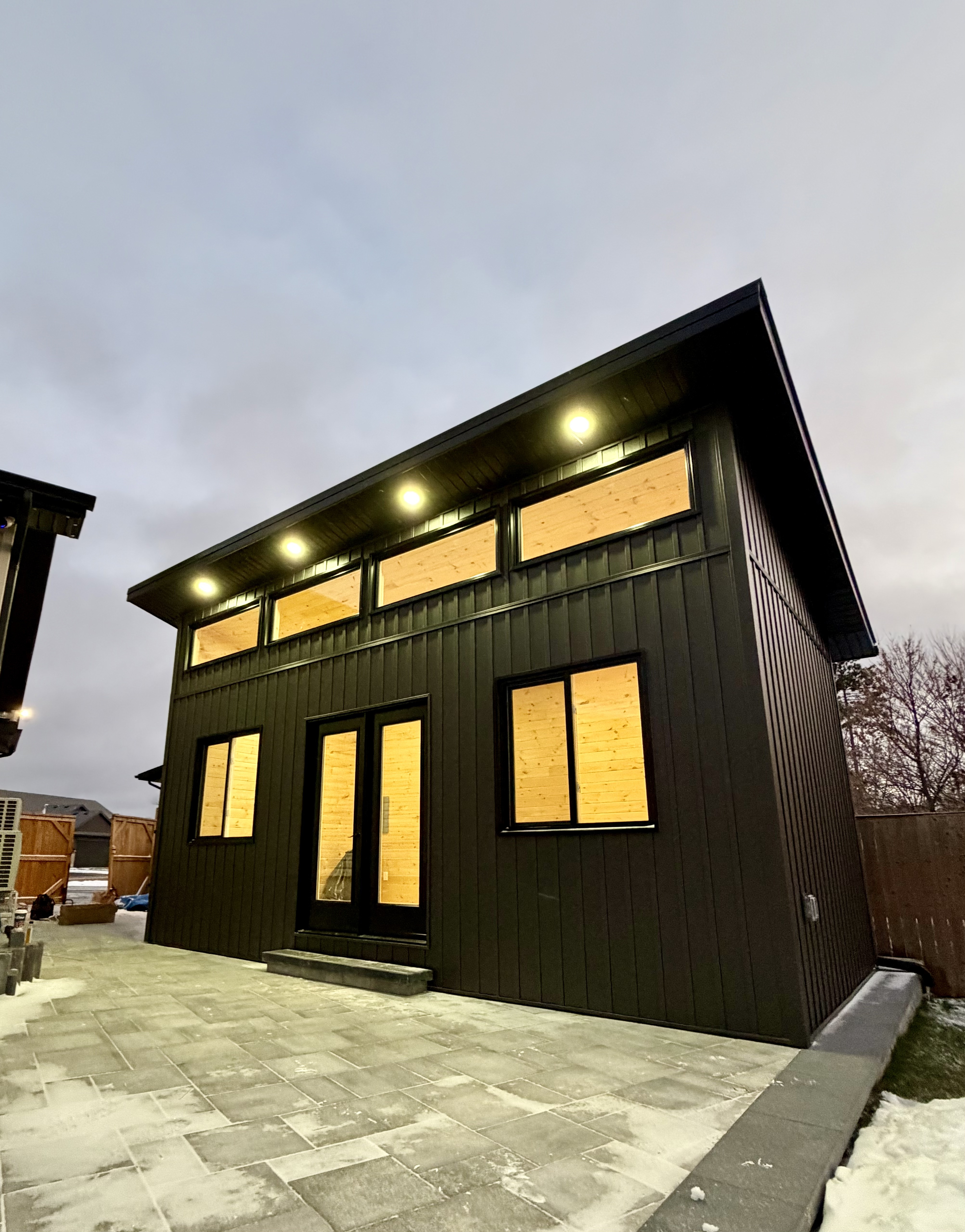 Modern custom building with black siding at dusk