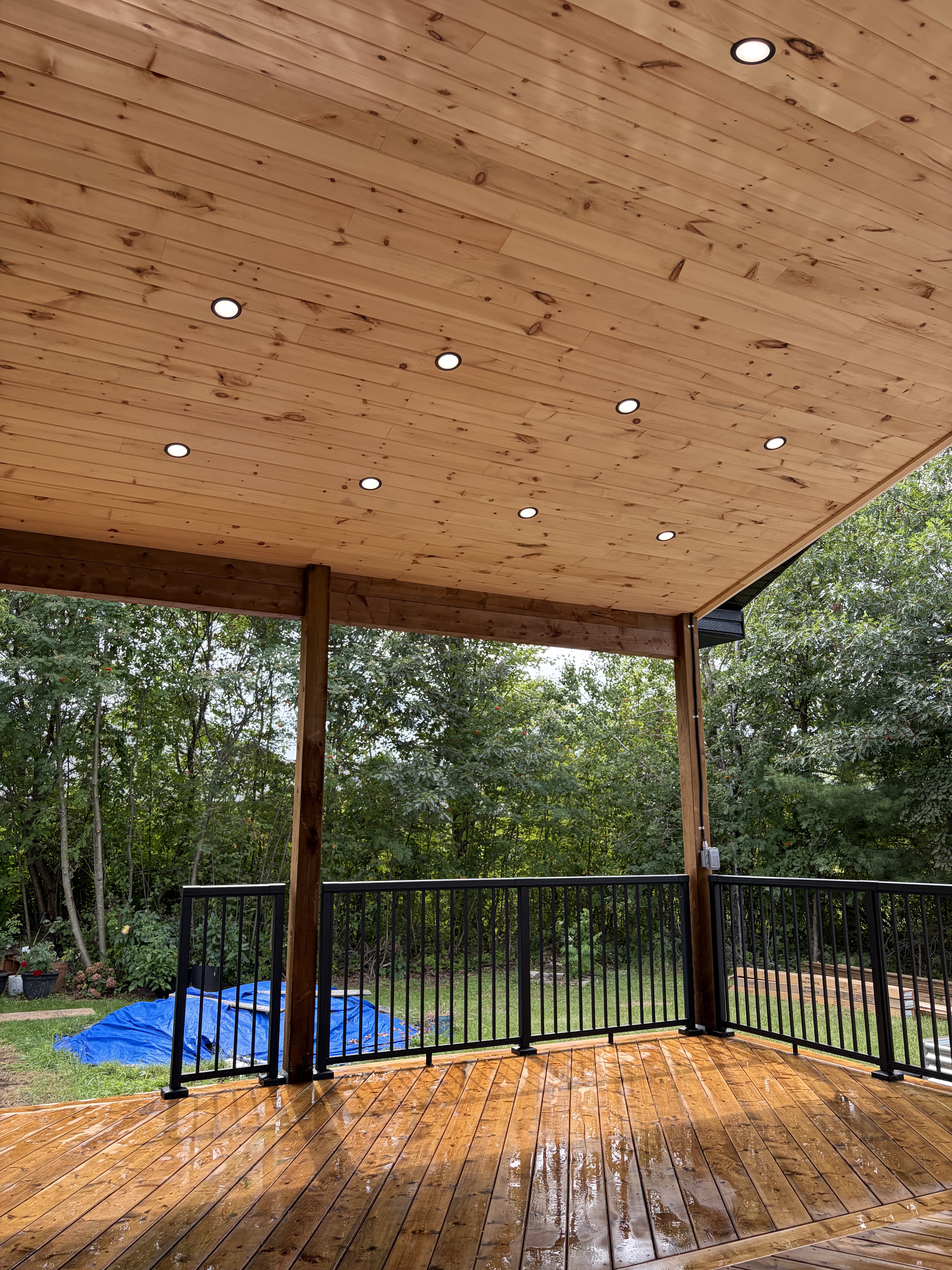 Cedar ceiling with recessed pot lights from inside covered deck