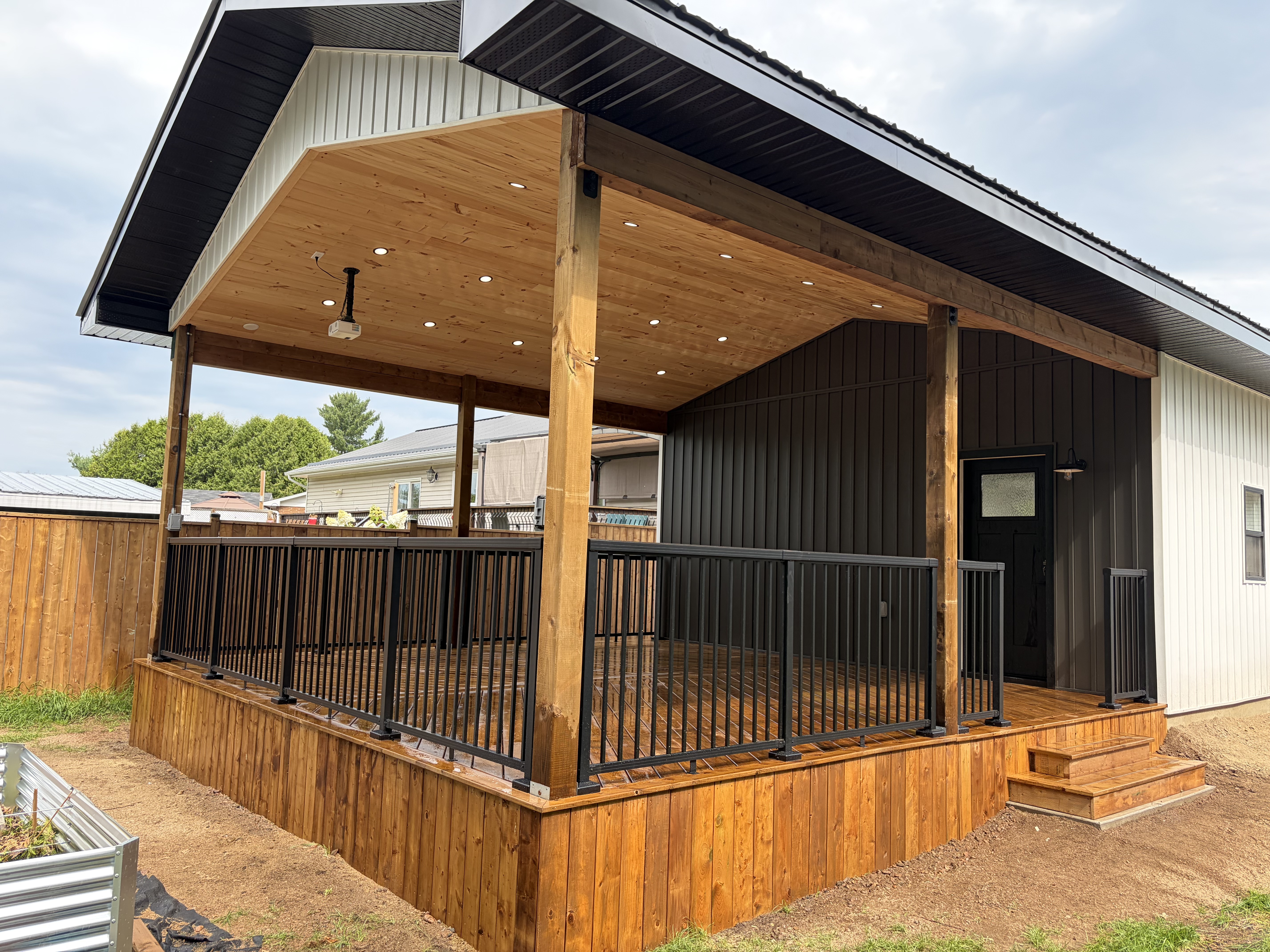 Custom garage with covered porch and black siding accent