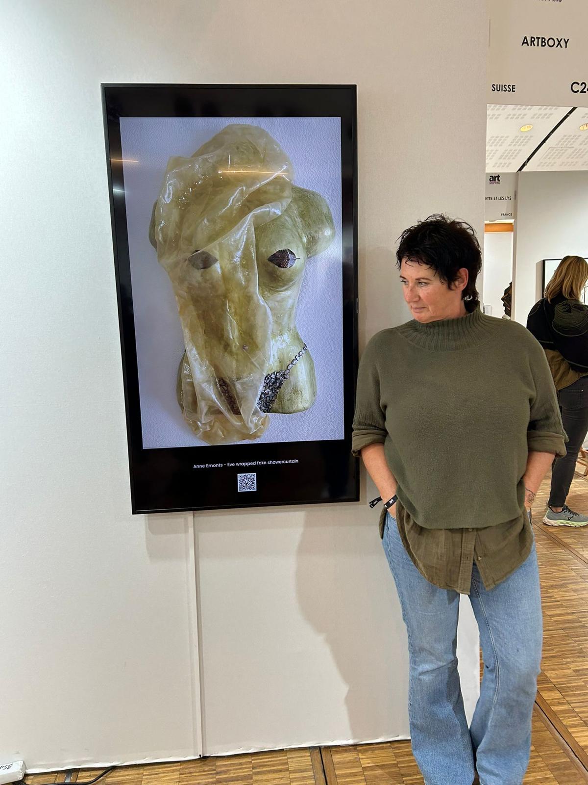 Anne beside her 'Eve wrapped fckn showercurtain' displayed at ArtBoxy exhibition