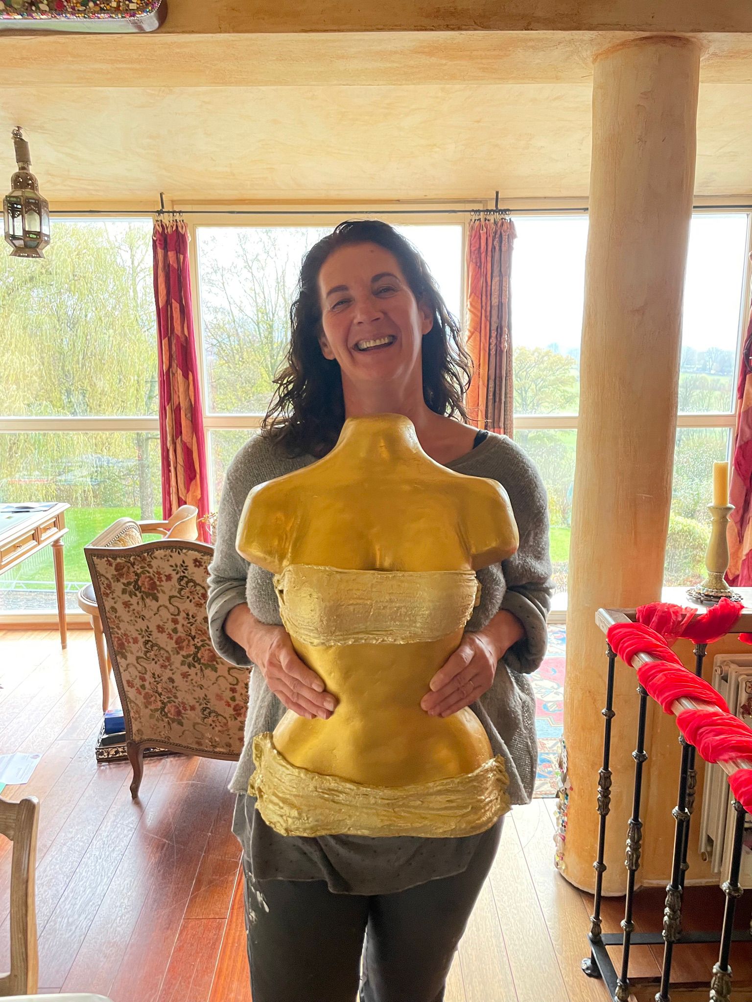 Anne Emonts holding a golden plaster bust sculpture
