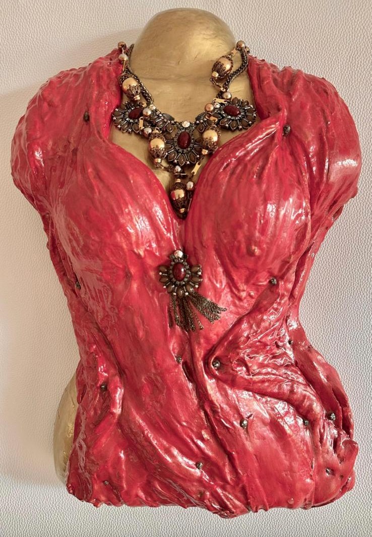 Red plaster bust with ornate bronze necklace