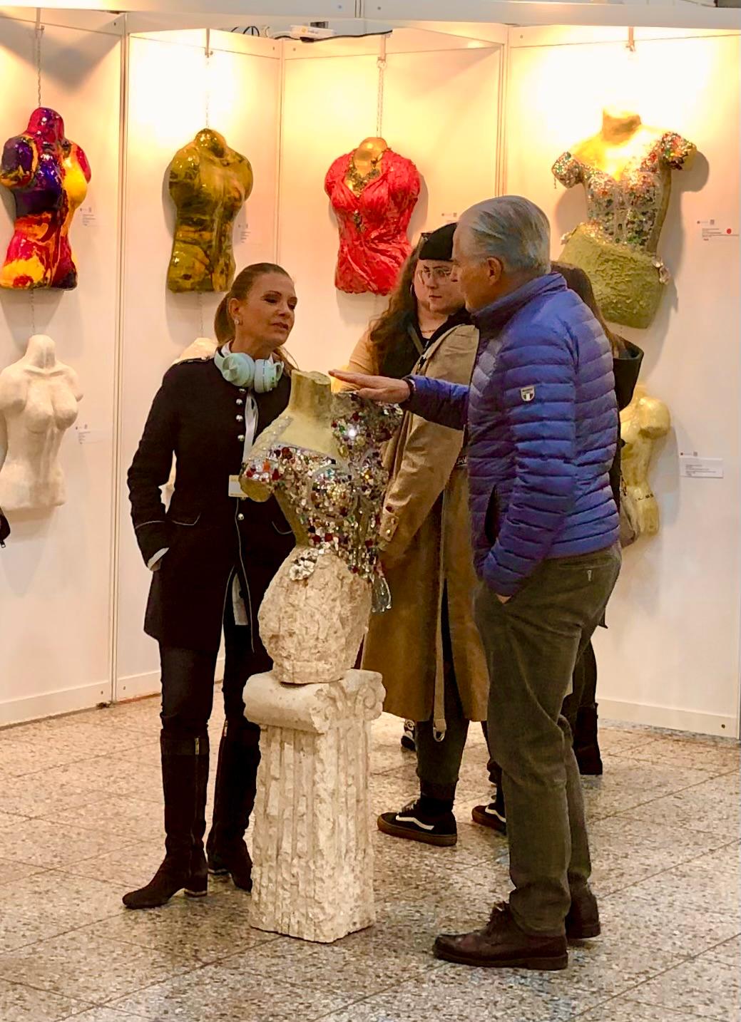 Anne discussing a jewelled bust sculpture with visitors at ARTe Dortmund